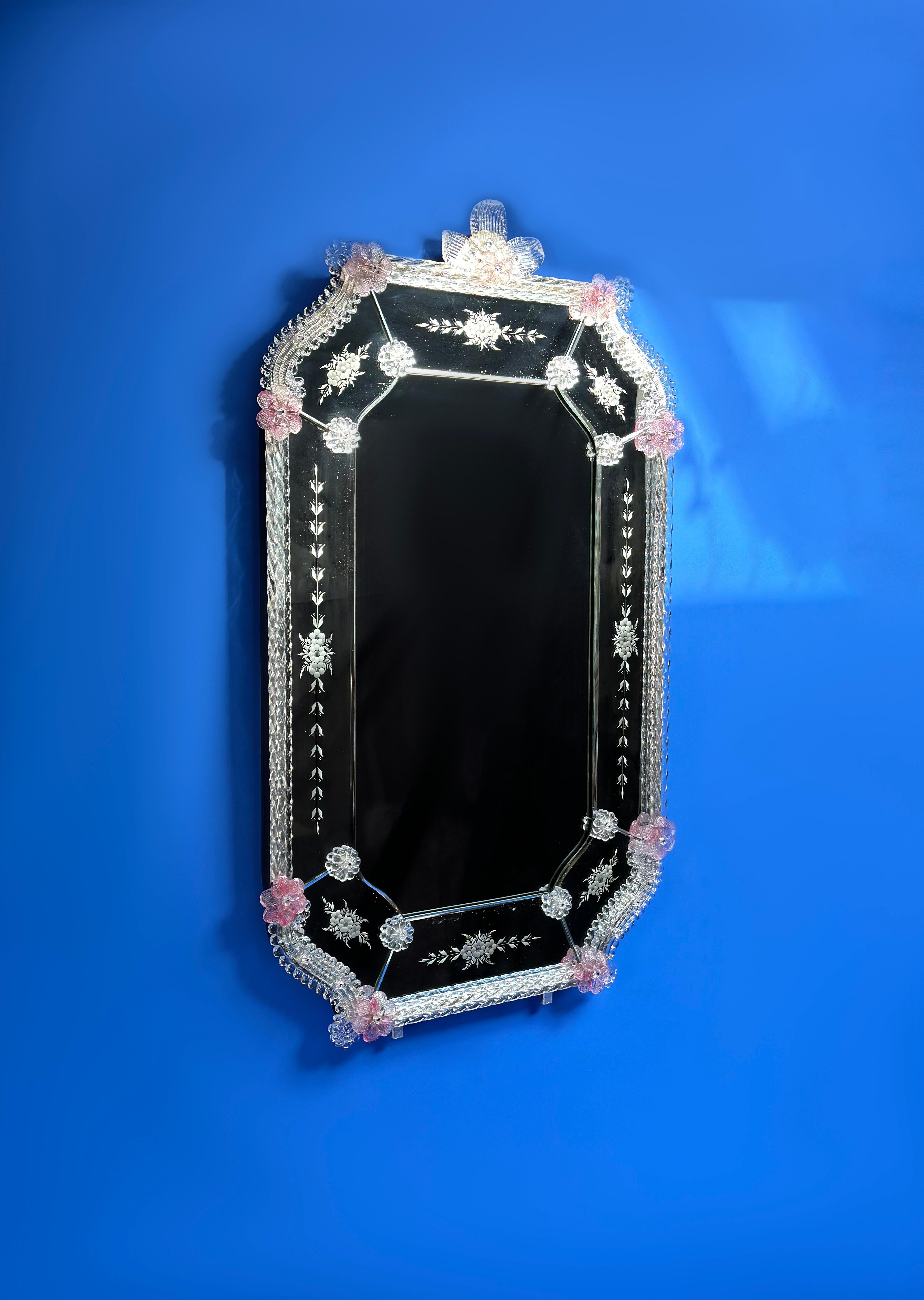 Un élégant miroir mural en verre vénitien. Fabriqué à la main à Venise dans les années 1960

Elle présente un ensemble de délicates décorations en verre, soigneusement disposées autour d'un cadre de forme octogonale.

Le miroir central est entouré
