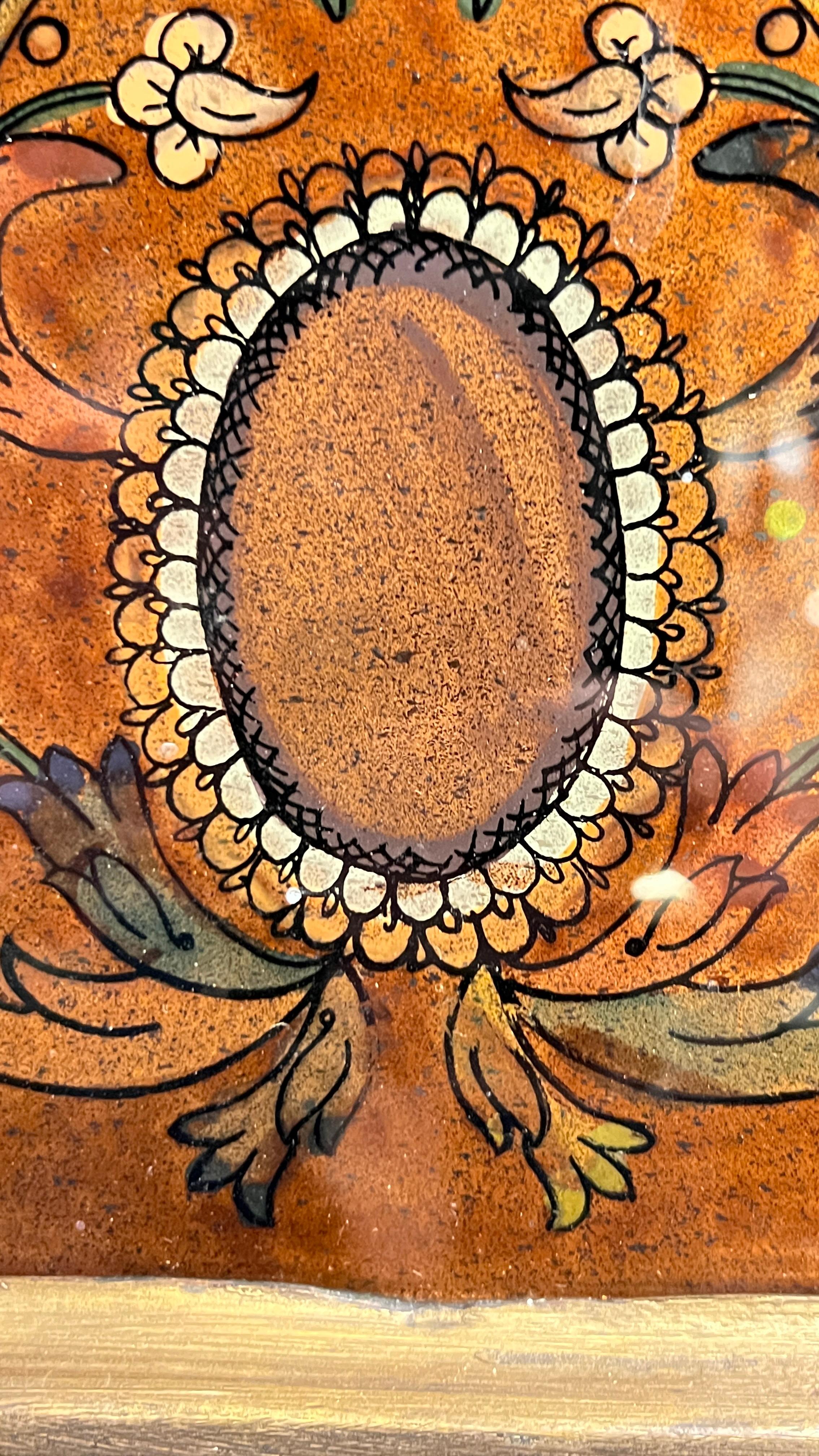 Precioso espejo vintage con diseños de cristal pintados a mano al revés en un marco de madera de forma octogonal.