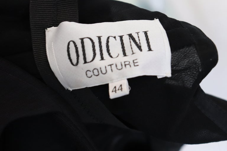A stunning evening gown by Odiccini Couture. The gown has elbow length sleaves  with sequin and bead detail , and a fully lined tiered silk skirt.  It has a side zip.