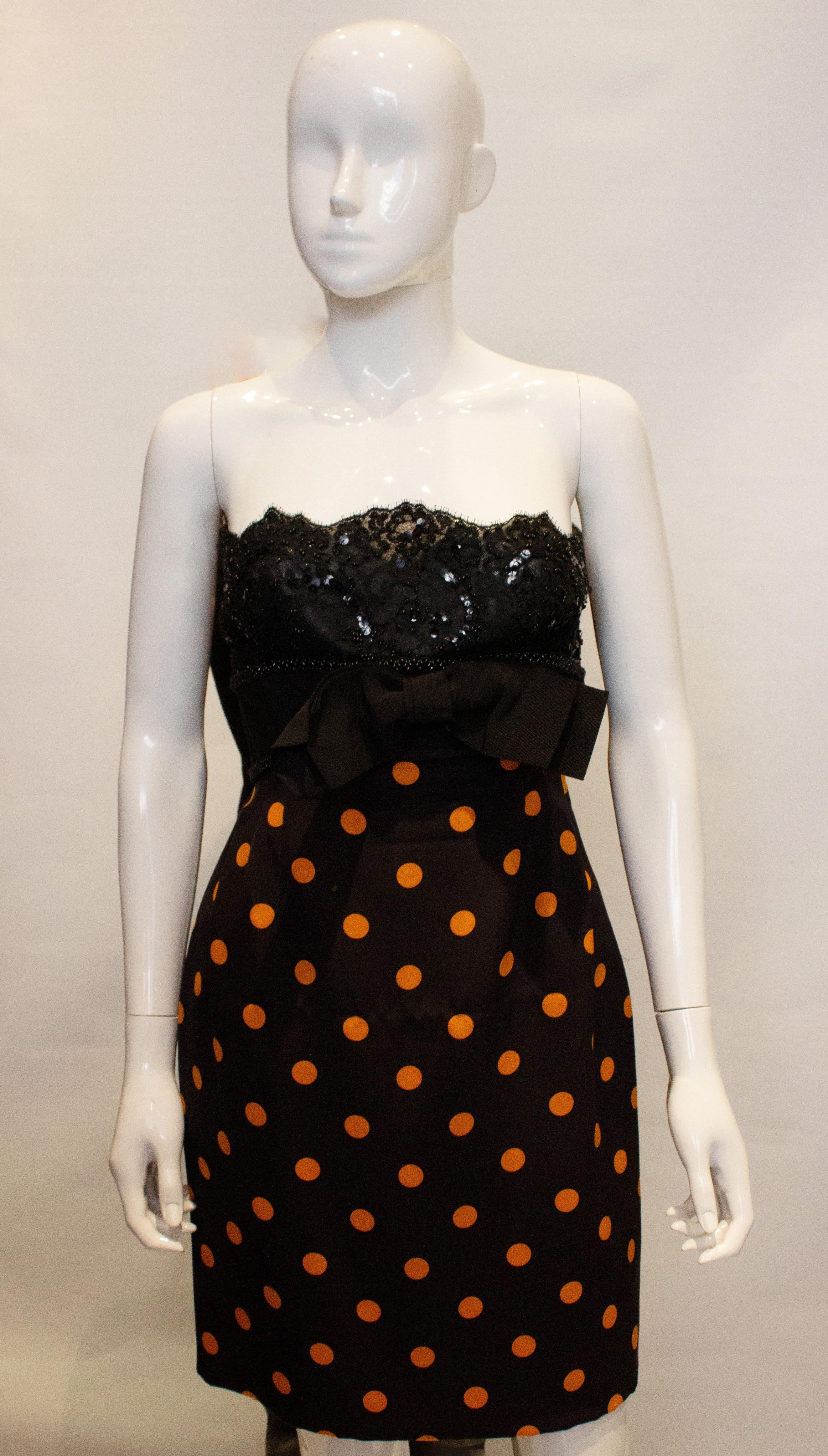 A chic and pretty vintage cocktail dress by Odicini Couture. The dress has a lace top and spot skirt with bow at the front. It is strapless but shoulder straps could easily be added. The dress is fully lined with a side zip. Measurements: Bust 36'',