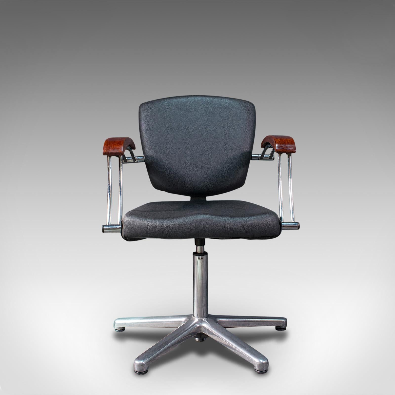 
This is a vintage office chair. An English, faux leather and beech adjustable desk seat, dating to the late 20th century, circa 1980.

Elegantly formed to add a dash to the office
Displays a desirable aged patina and in superb original