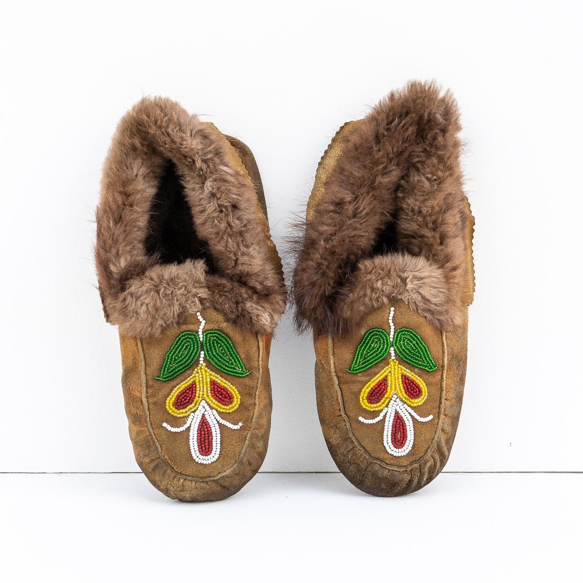 CHAUSSURES TRIBALES TRADITIONNELLES OJIBWAY AVEC DÉTAILS FLORAUX EN PERLES
Originaire du peuple Ojibwe (Ojibwa) de ce qui est aujourd'hui le sud du Canada et le nord du Midwest des États-Unis.

Fabriqué à la main en cuir d'élan fumé et garni de