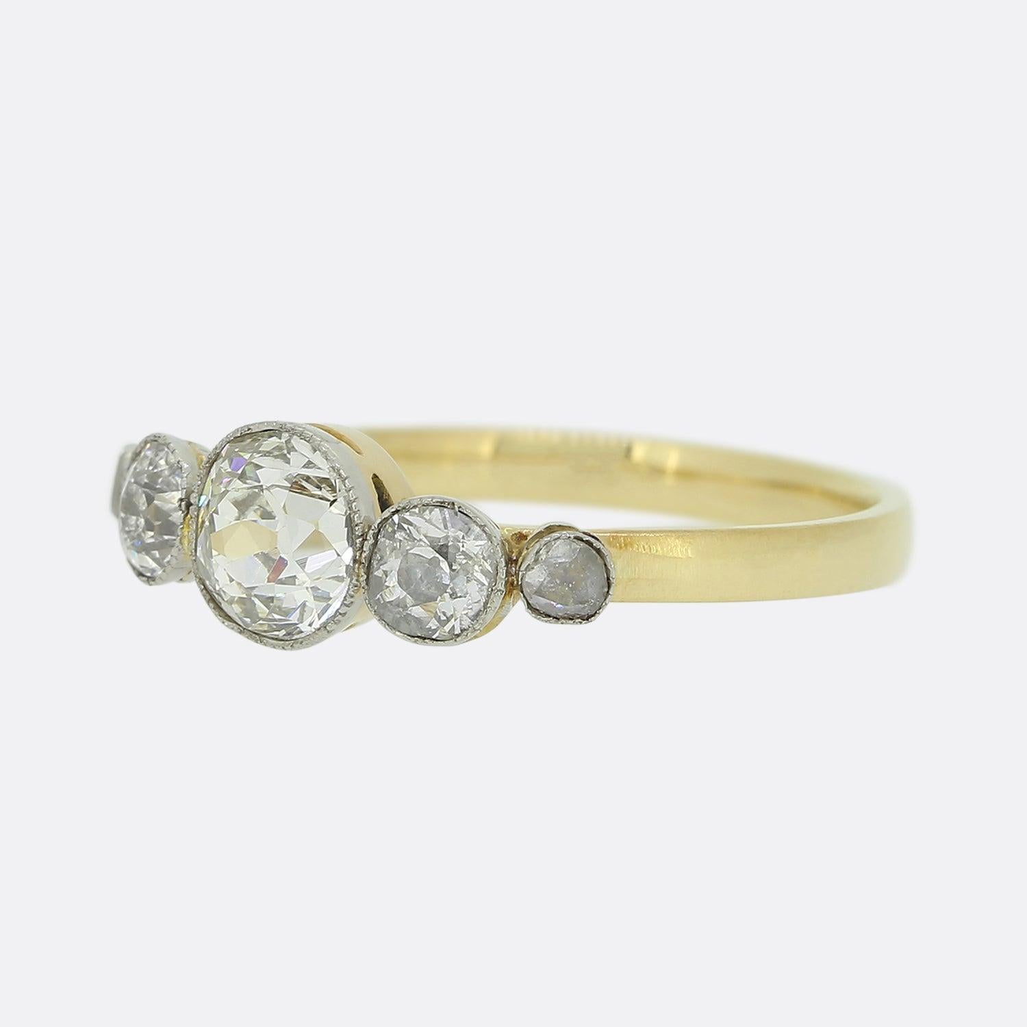 Here we have a wonderfully arranged vintage five stone diamond ring. A sizeable old cut diamond sits at the centre which is flanked on either side by a slightly smaller matching old cut diamond. A rose cut diamond at either end of the line formation