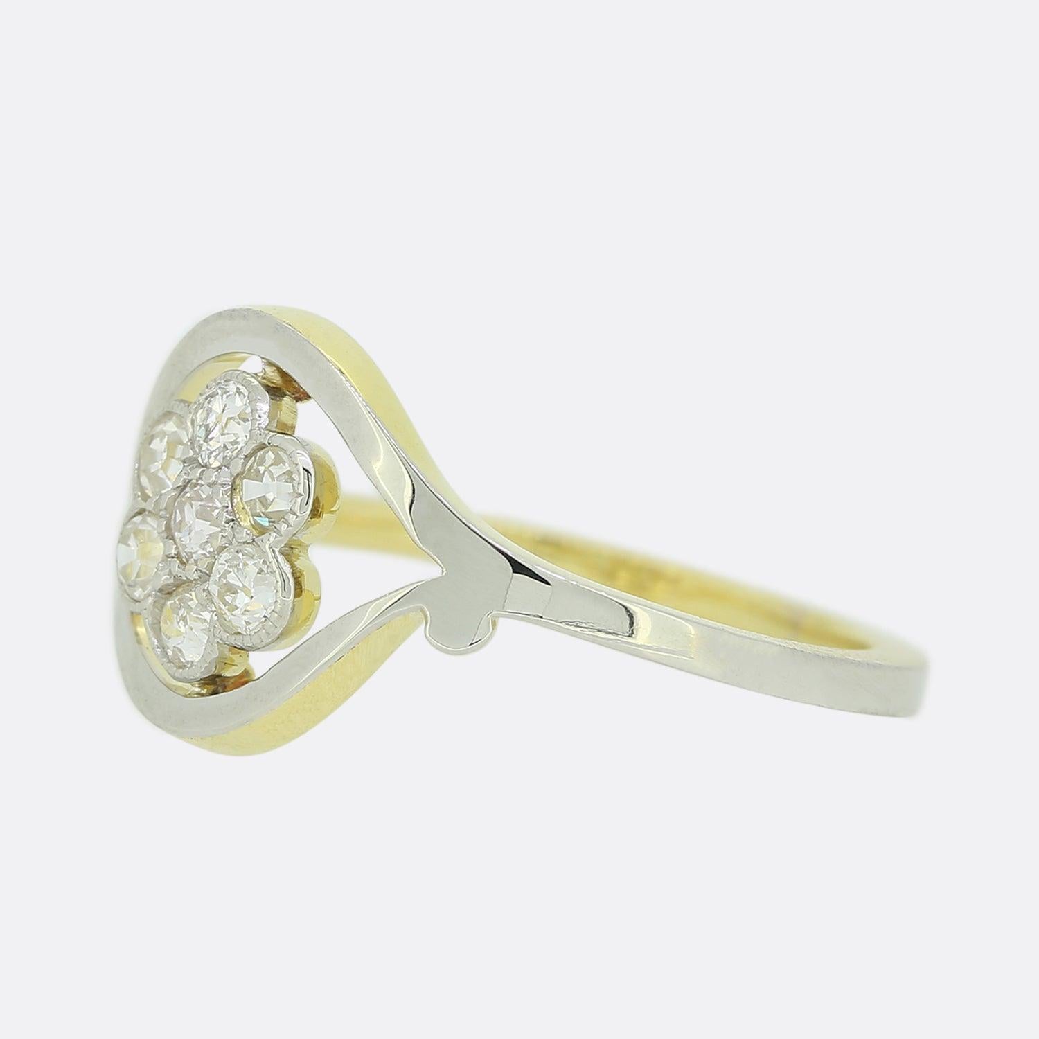Here we a wonderful 18ct white and yellow gold diamond cluster ring. The head of the piece presents an open structure showcasing a total of  seven closely milgrain set old cut diamonds.  

This ring started life as a vintage brooch but has been