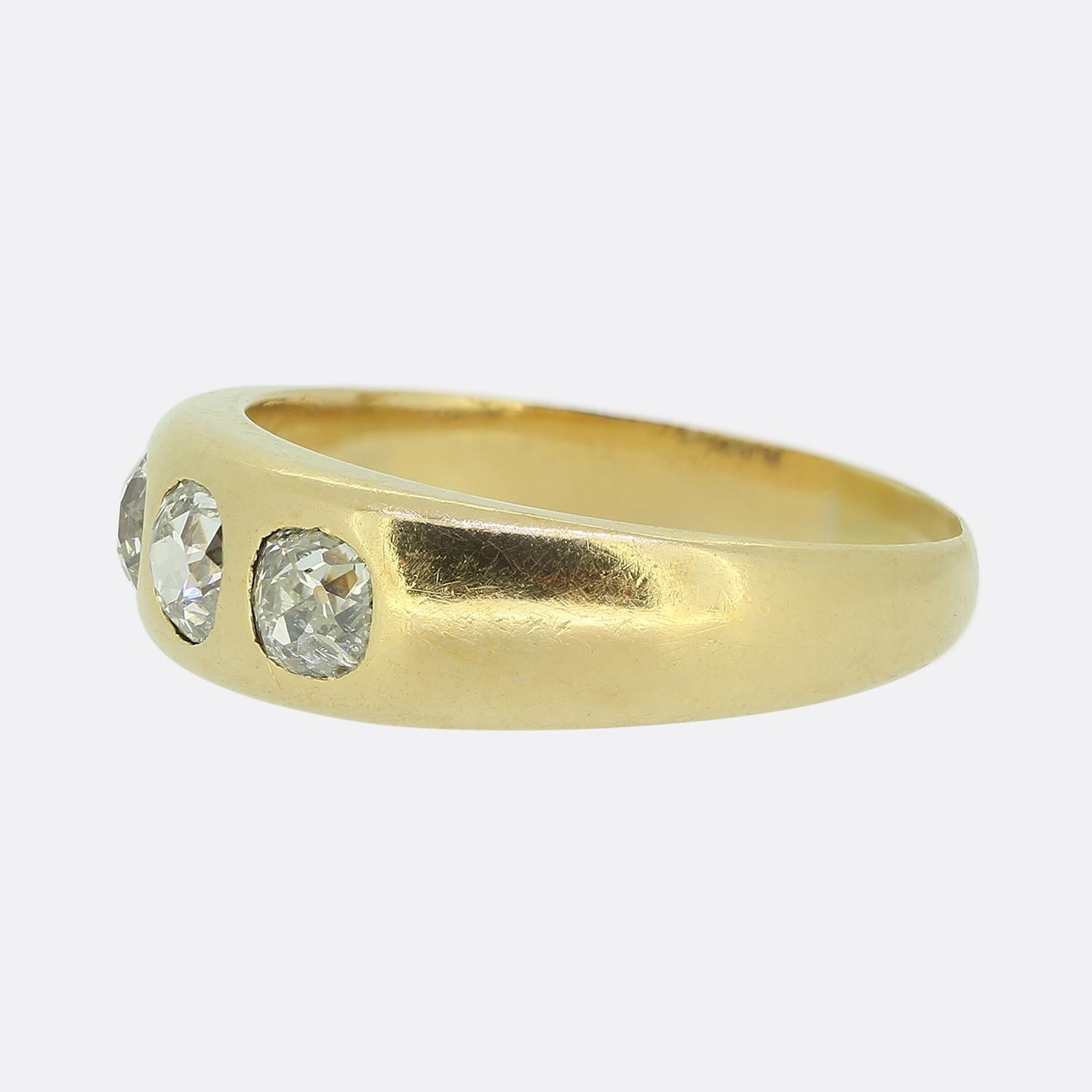Here we have a wonderfully crafted diamond three-stone ring. This simple yet stylish vintage piece features a trio of old cushion cit diamonds; each of which has been individually bezel set in a collective line formation atop an 18ct yellow gold