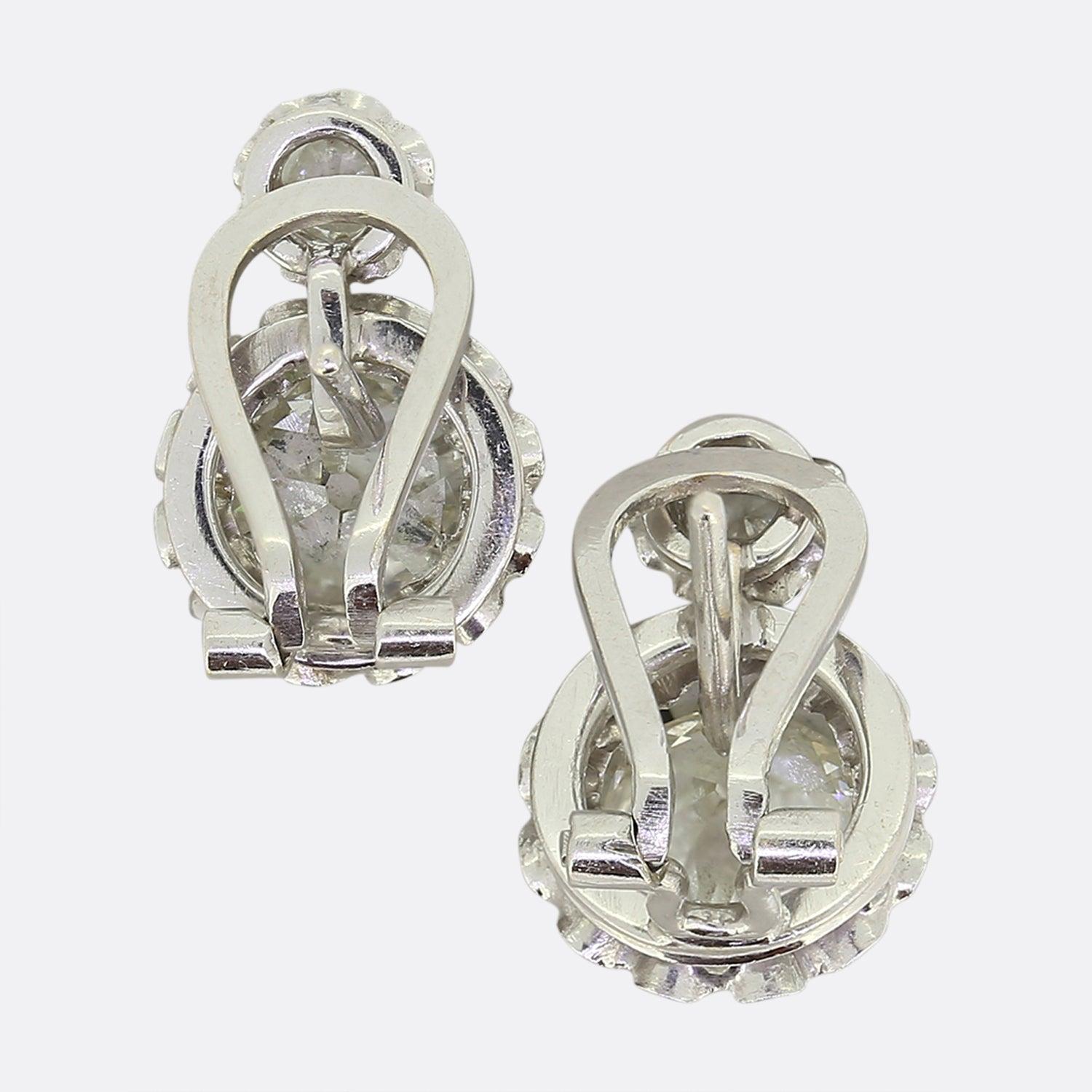 This is a wonderful pair of diamond earrings that date back to the 1950s. Each earring features a small and large old cut diamond that are illusion set in platinum to make them appear even larger. The diamonds are well matched and beautiful chunky