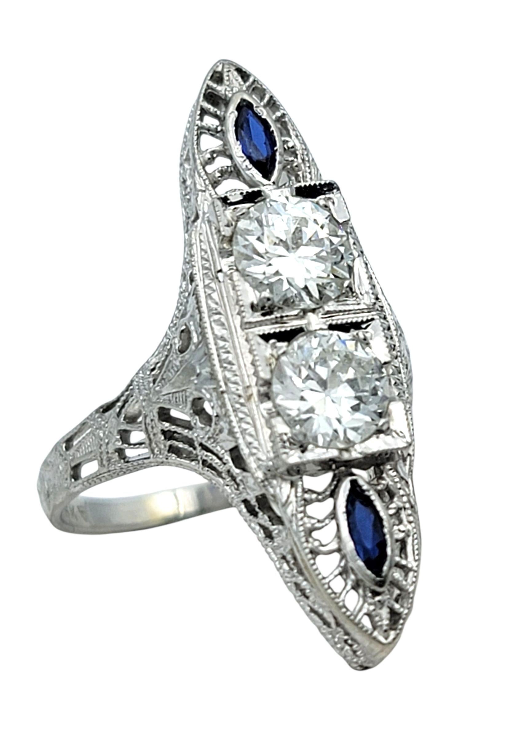 Ring Size: 5.25

This eye-catching ring showcases a romantic vintage design centered around two shimmering Old European cut diamonds. Framed on each end by vivid marquise-cut blue sapphires, the arrangement creates an elegant vertical silhouette