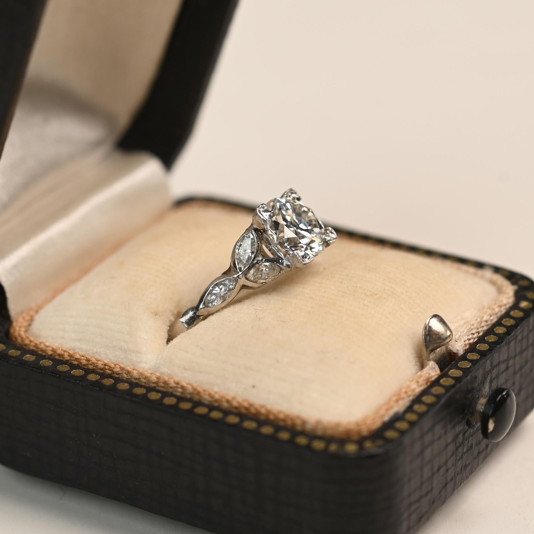 A stunning vintage ring showcasing an approximately 1.00-carat Old European cut diamond at its center, graded J in color and VS2 in clarity. The diamond is secured in a classic box prong setting, allowing its antique facets to catch the light