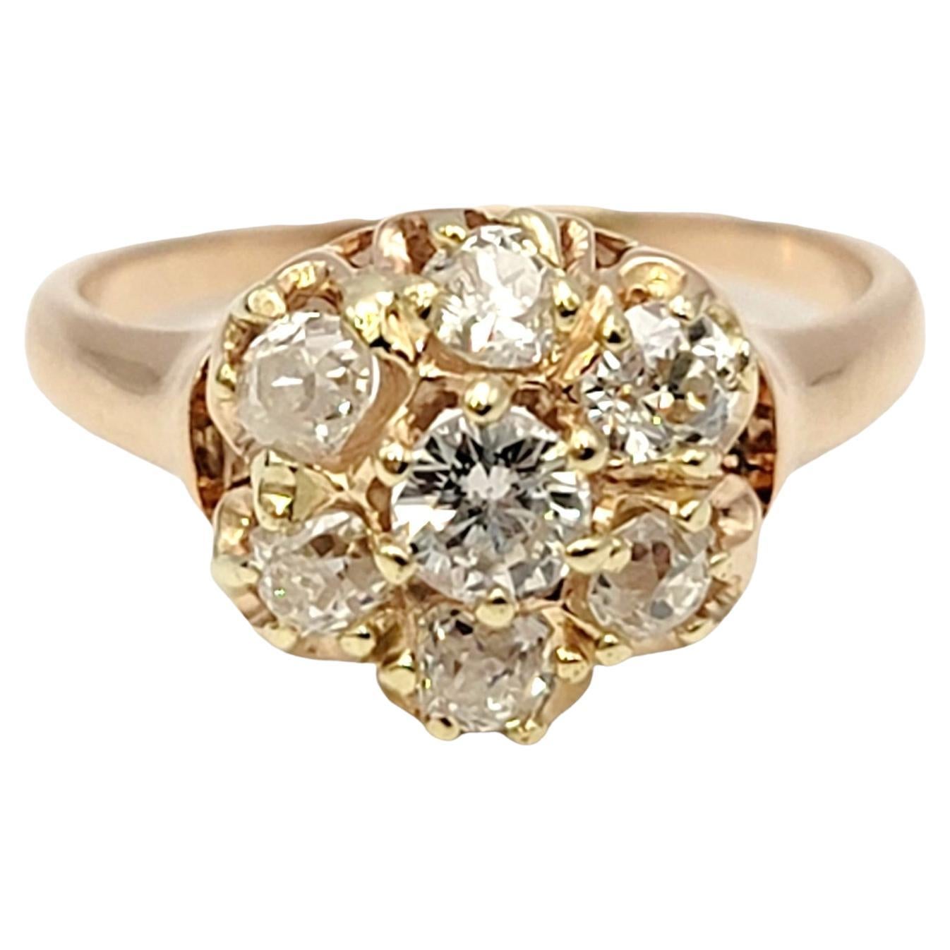 Taille de l'anneau : 4.5

Cette bague vintage romantique présente 7 incroyables diamants de taille Old European sertis en grappe arrondie au centre de l'anneau, formant un motif de style floral. Décalées par une délicate tige en or jaune, les
