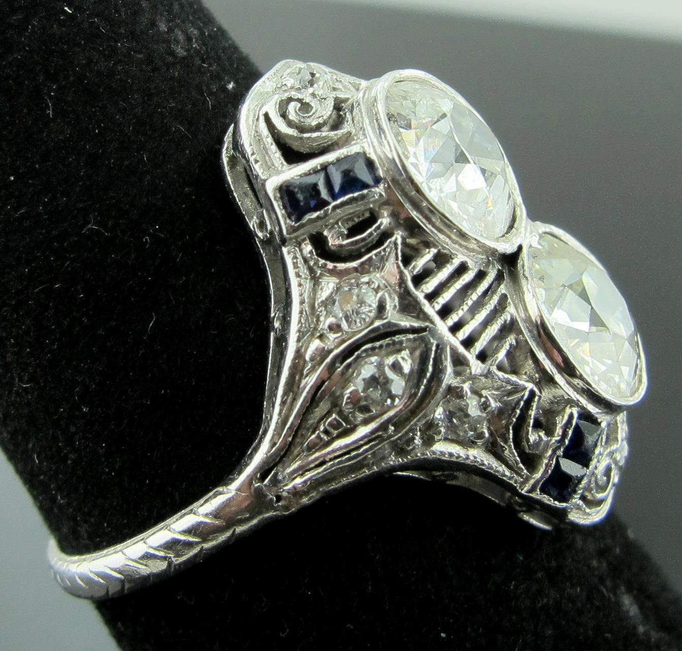 Diamantring aus den 1920er Jahren mit zwei Diamanten von je etwa 1 Karat. Old European Cut-Diamanten mit einem Gesamtgewicht von 2,15 Karat.  Farbe M-N, Reinheit VS und Farbe H-I, Reinheit I1.  8 weitere Diamanten im alteuropäischen Schliff mit