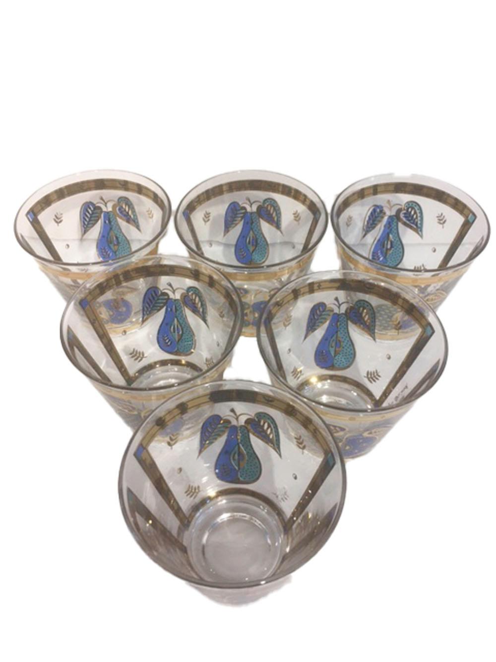 Mid-Century Modern old fashioned glasses by Georges Briard in the Forbidden Fruit pattern. Each of clear glass decorated in translucent blue and green enamel and 22 karat gold. Each glass has a pear on one side and an apple on the other within an