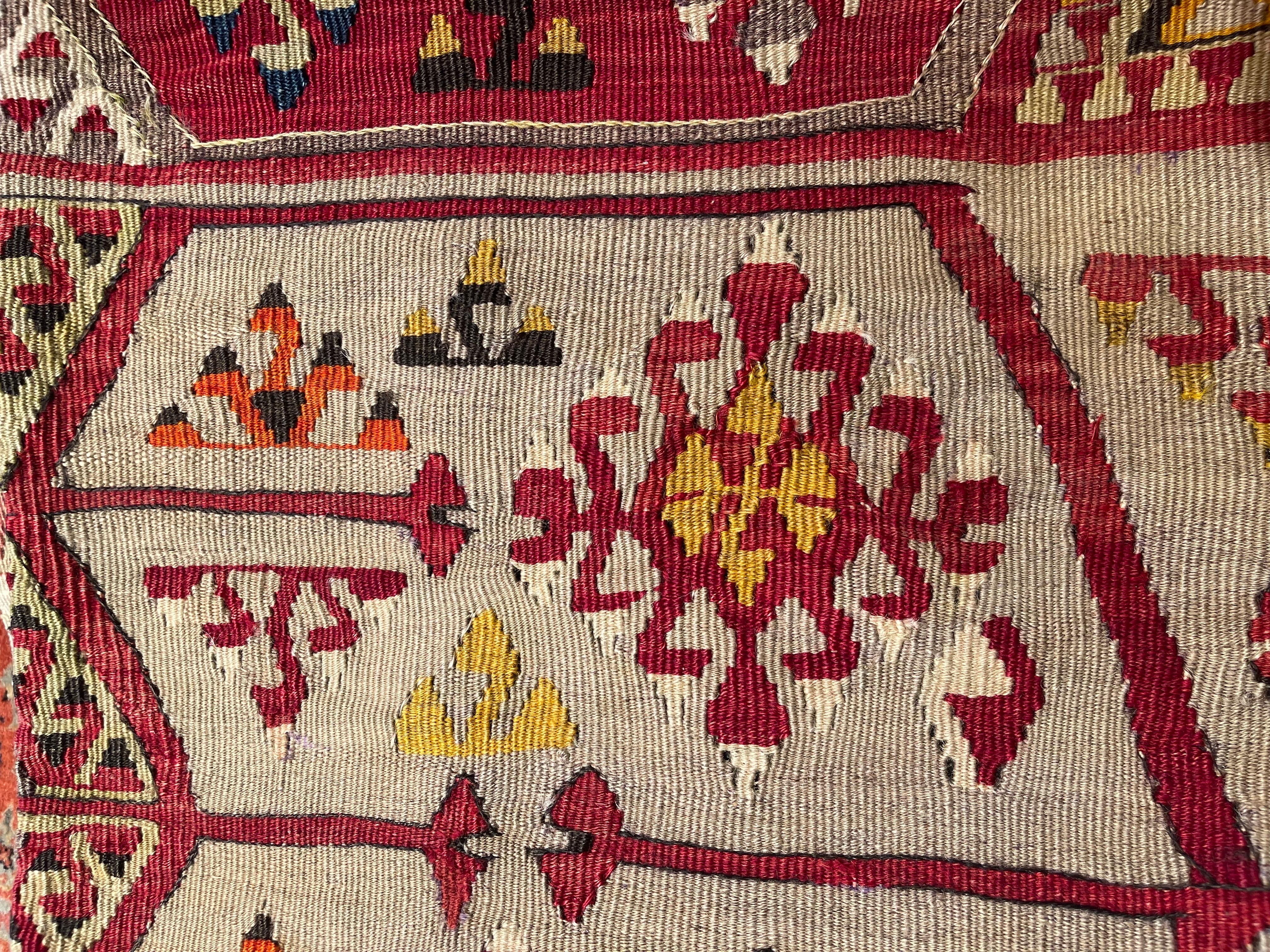 Nous avons fabriqué une housse de coussin en utilisant les parties intactes des kilims anciens et antiques, précieux et de grande qualité, qui ne peuvent être réparés. Comme une peinture, une partie du paysage est découpée dans un kilim, et même