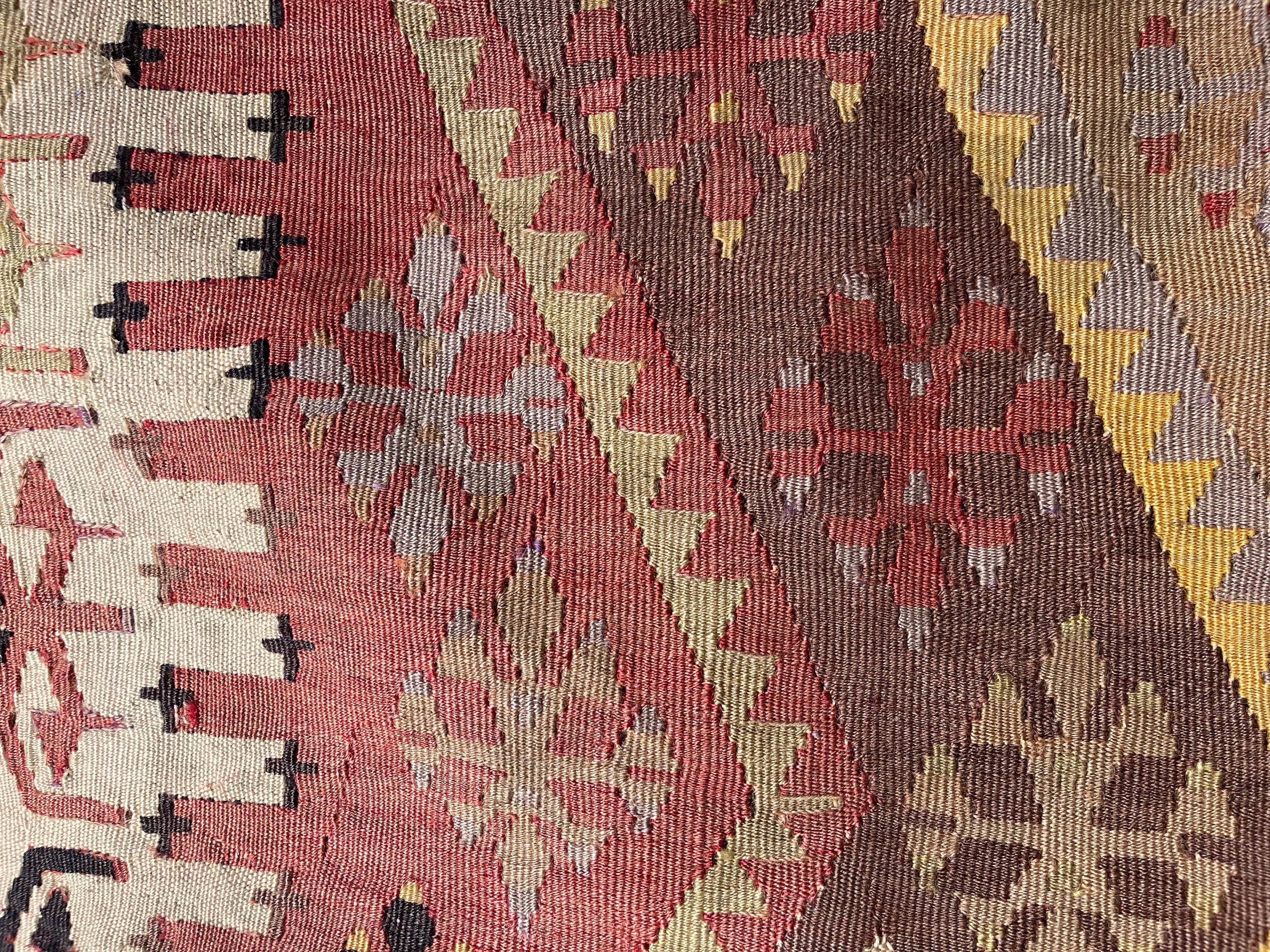 Nous avons fabriqué une housse de coussin en utilisant les parties intactes des kilims anciens et antiques, précieux et de grande qualité, qui ne peuvent être réparés. Comme une peinture, une partie du paysage est découpée dans un kilim, et même