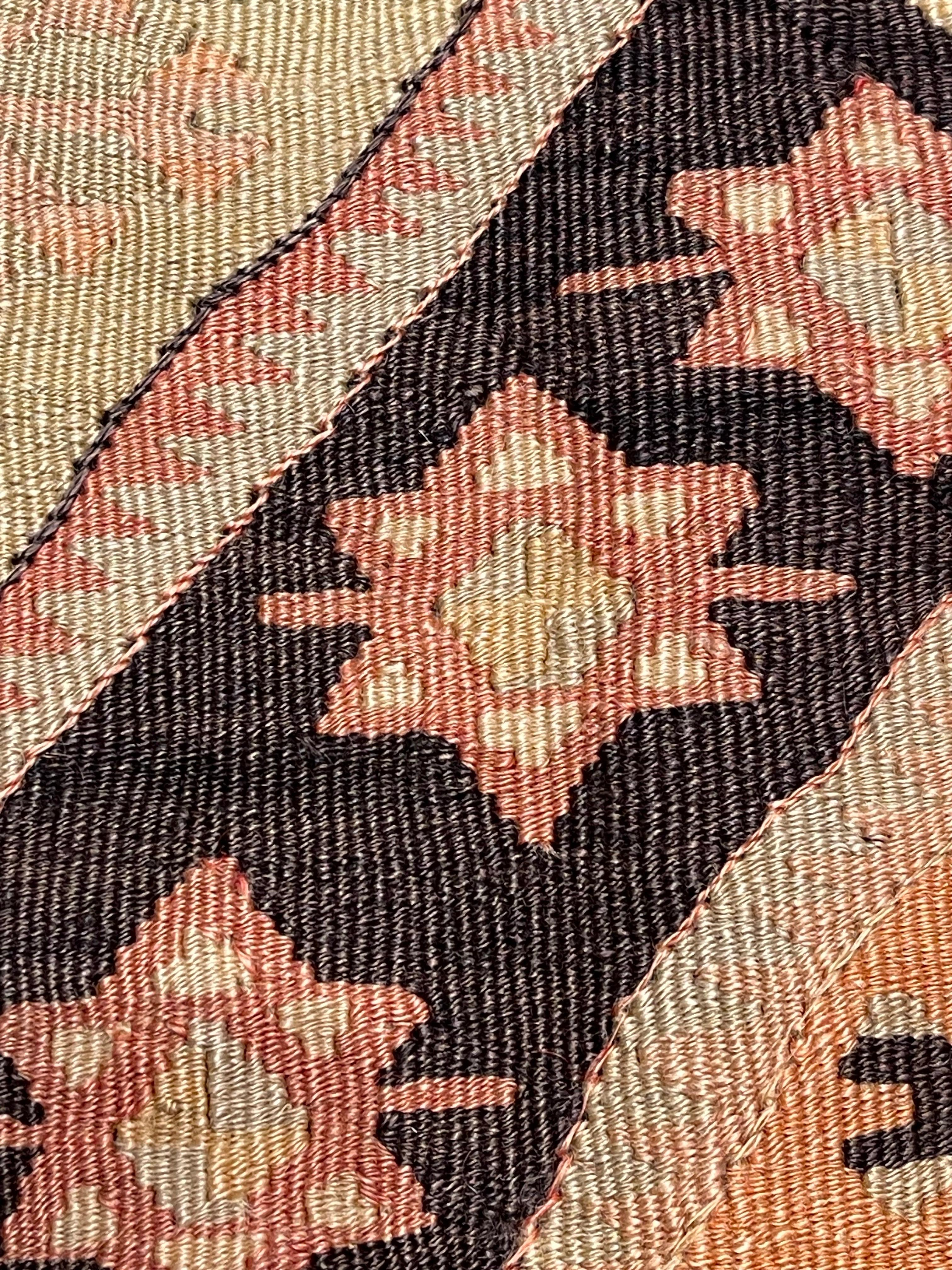 Questo splendido copricuscino artigianale è ricavato da un kilim vintage dell'Anatolia, un tempo parte di un tradizionale yastik, un piccolo tappeto decorativo utilizzato nelle case turche. Tessuto a metà del XX secolo con lana filata a mano e