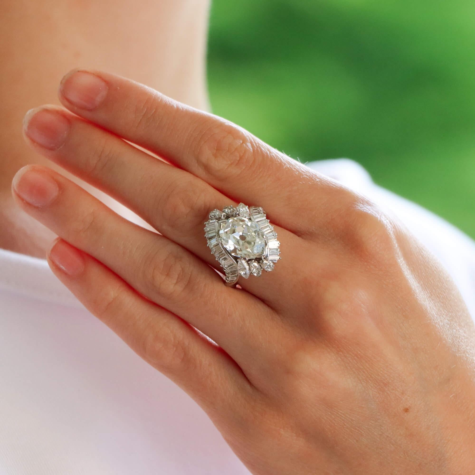 Un precioso anillo en racimo marquesa de talla antigua engastado en platino.

El anillo está engastado principalmente con una piedra marquesa de talla antigua, única y rara de encontrar, engarzada con seguridad con 6 garras en una montura