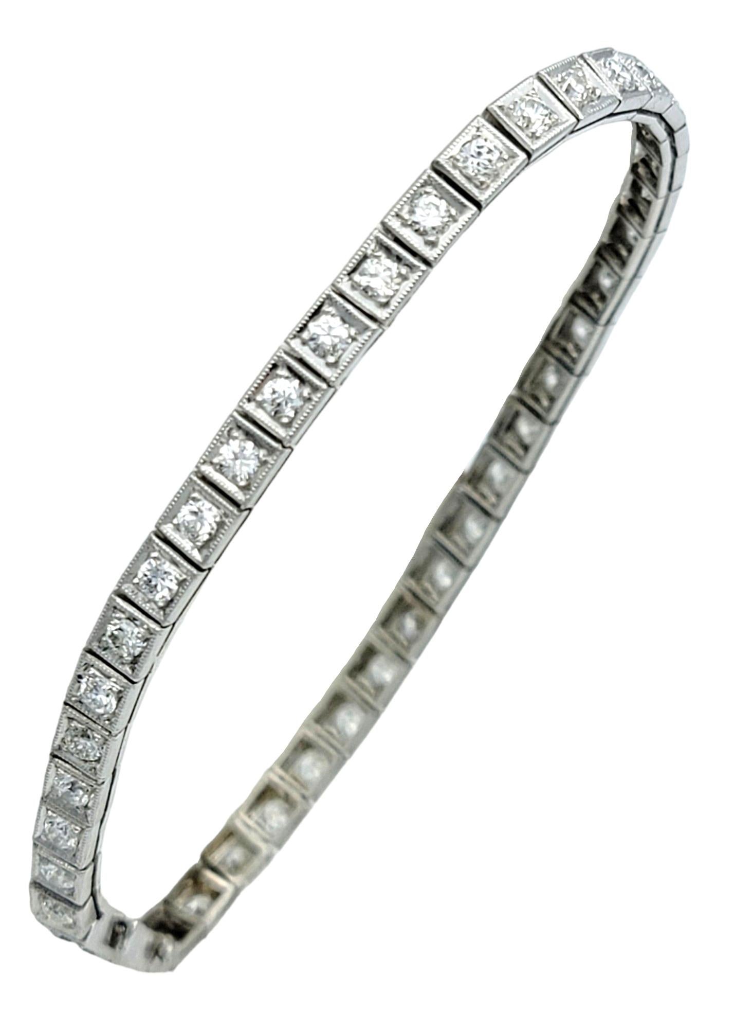 Questo splendido braccialetto tennis con diamanti vintage è squisitamente realizzato in platino con un sofisticato design squadrato e un'intricata texture milgrain. Questo incredibile bracciale è caratterizzato da una linea continua di diamanti