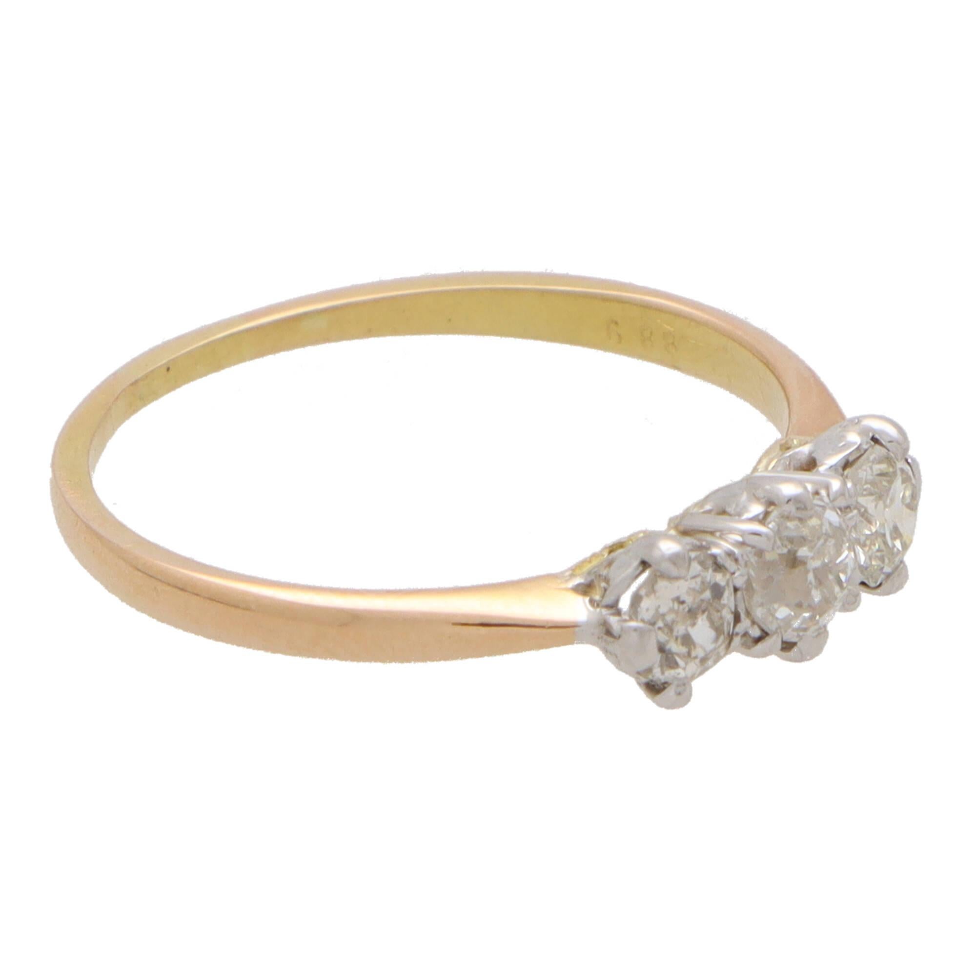 A beautiful vintage old mine cut diamond three stone ring set in 18k yellow and rose gold.

The piece is composed of three sparkly old mine cut diamond stones which are all claw set securely.  Uniquely the inner band is yellow gold and the outer