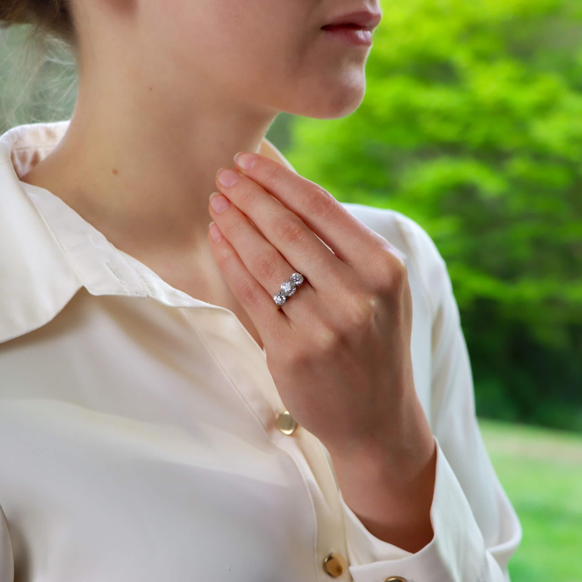  A beautiful vintage old mine cut diamond three stone ring set in 18k yellow gold.

The piece is centrally set with a sparkly 1.33 carat old mine cut diamond which is securely 8 claw set to centre. To either side of the central diamond are two other