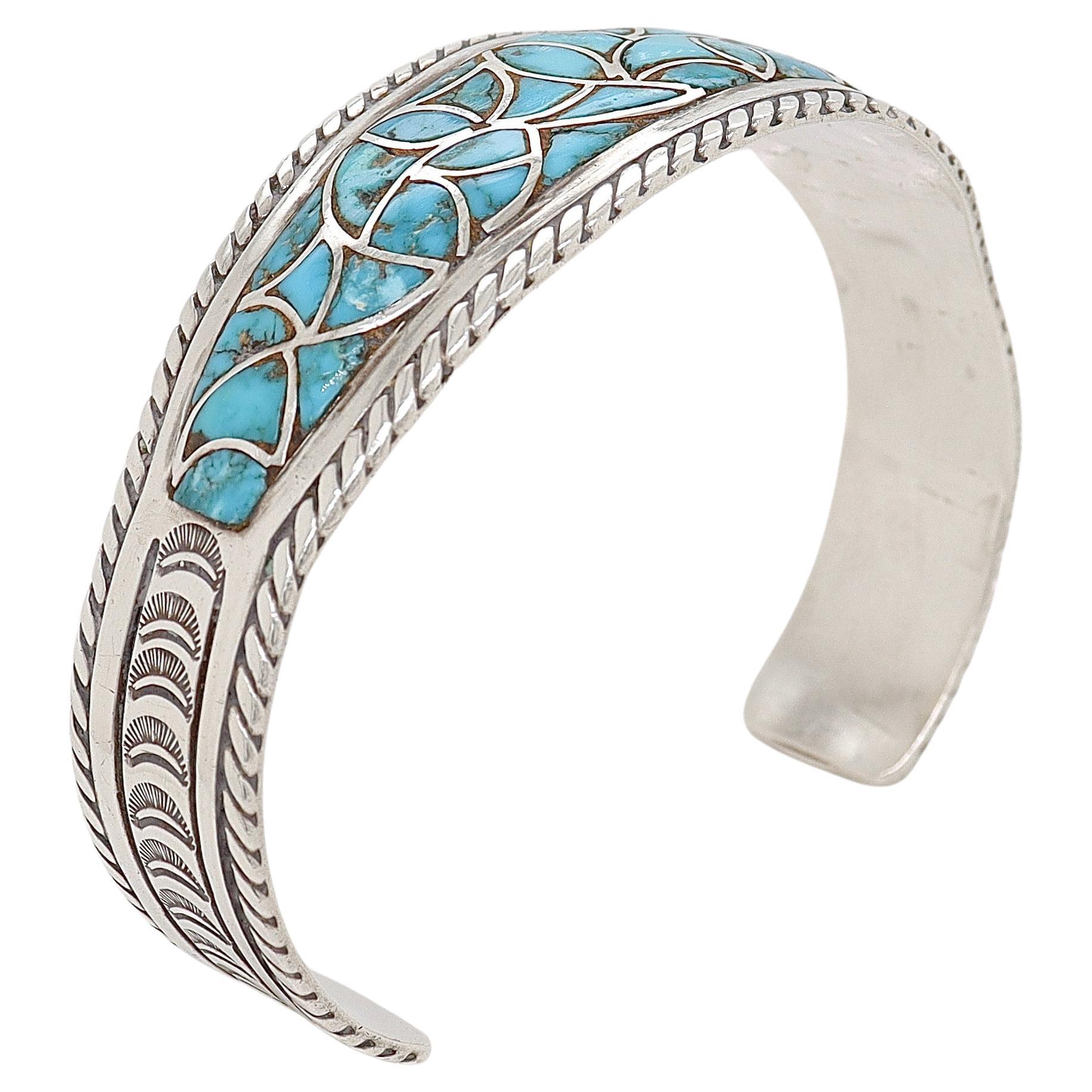 Un beau bracelet de manchette vintage en argent Navajo de Old Pawn.

Incrustée de turquoise et travaillée avec des décorations martelées à la main et des bords torsadés en corde tout au long de l'ouvrage.

Tout simplement un merveilleux bracelet