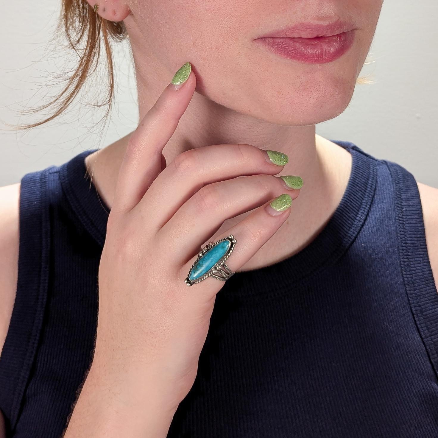 A fine vintage Navajo ring.

In solid silver (likely sterling) with wire twist decoration. The shank with stylized punched snake and squiggle decoration.

Bezel set with an oval turquoise cabochons.

A fine Old Pawn ring!

Date:
Mid-20th