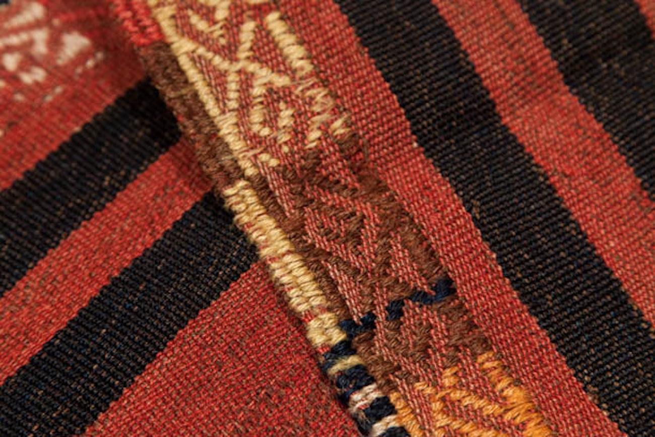 Se trata de un Sofreh, un tipo de kilim utilizado tradicionalmente para servir comidas. Debido a su finalidad, se teje con una trama plana especialmente suave y suelta, que lo hace más fino y flexible que los kilims típicos. Los elementos