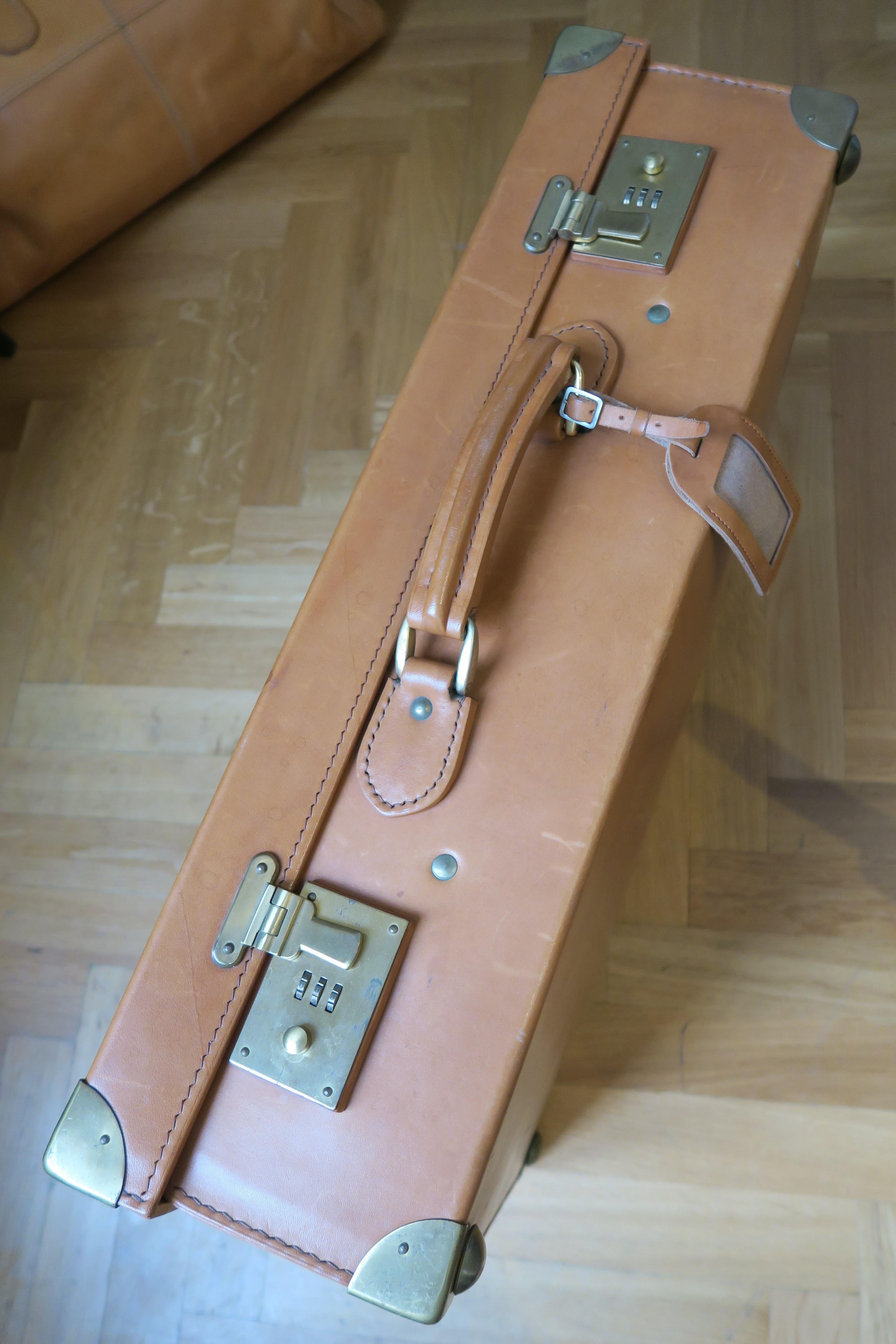 The item on sale is a beautifully constructed suitcase made from cowhide. All the handles, zippers and flaps look untouched. It comes with a matching label for the owner's address and brass hardware. The inside is silk lined. The bottom is still
