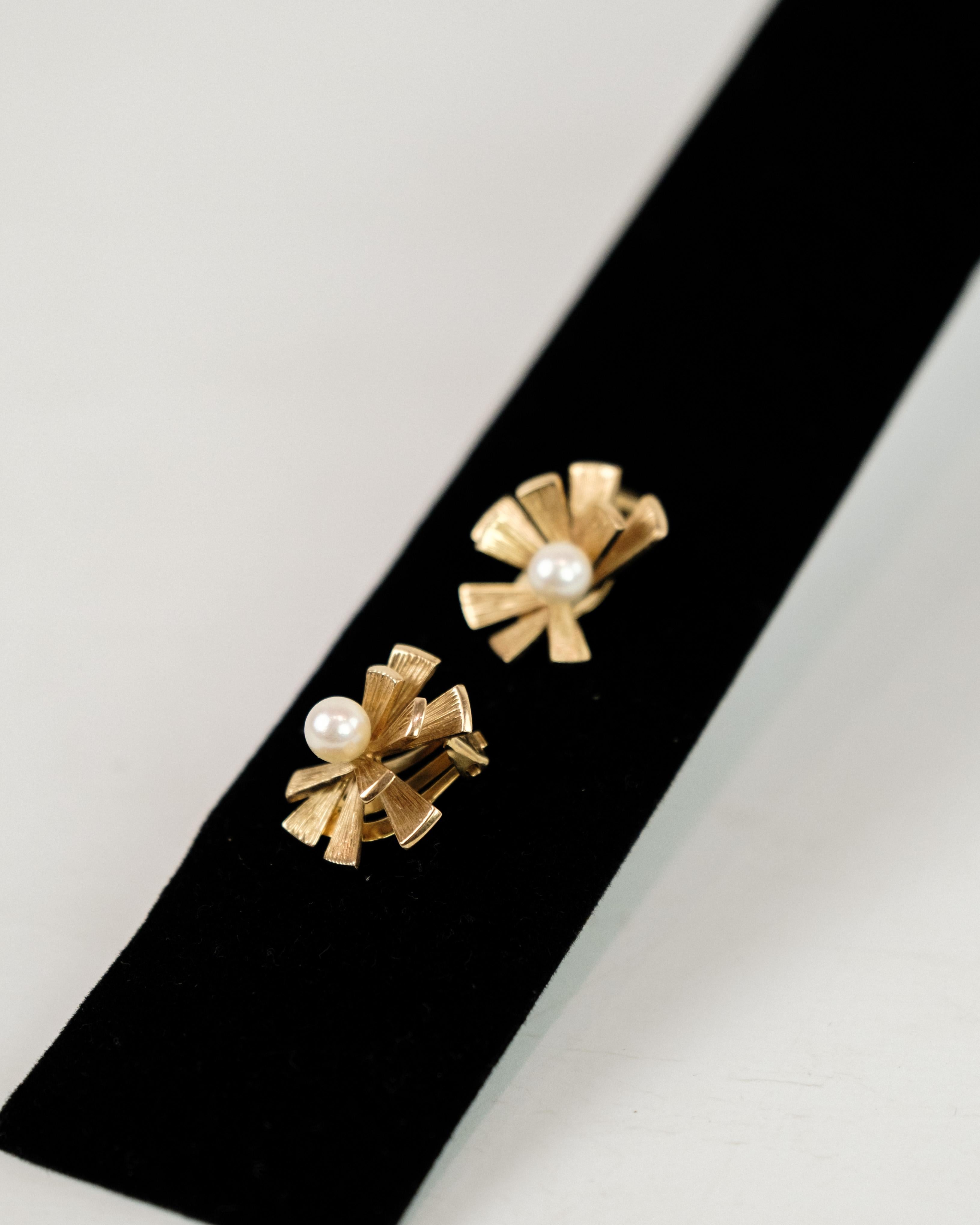 These vintage ear clips by Ole Lynggaard are exquisite pieces of jewelry crafted from 14-carat gold and featuring high-quality cultured pearls. The renowned Danish jeweler Ole Lynggaard is known for his meticulous attention to detail and exceptional