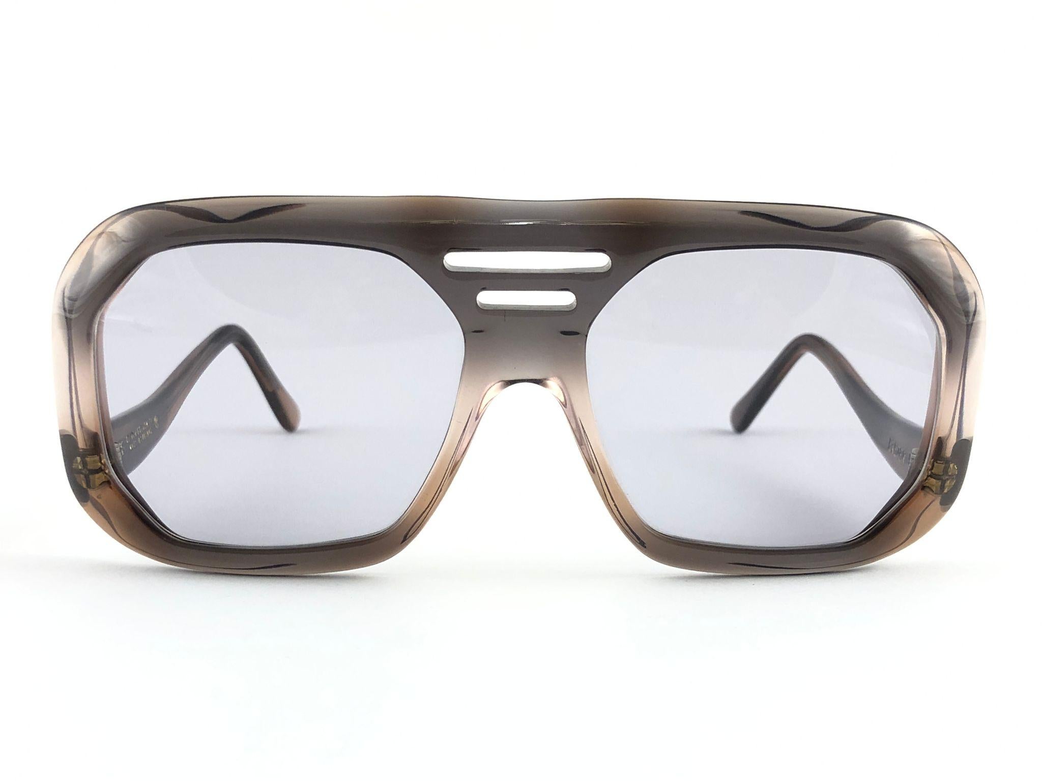 Oversized Ultraraare, une paire de lunettes de soleil Oliver Goldsmith robuste. 
Monture en paternité écaille claire avec une paire de verres gris moyen. 

Cette paire présente des signes mineurs d'usure dus au stockage.

Fabriqué à la main en