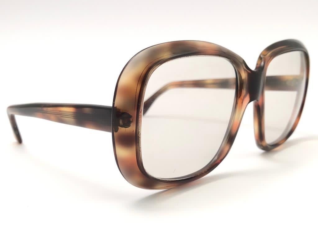 Oversized pair of Oliver Goldsmith sunglasses. 
Light tortoise paternities frame holding a pair of light lenses. 

This pair have minor sign of wear due to storage.

Handmade in England.


MEASUREMENTS

FRONT : 15 CMS

LENS HEIGHT : 5.2 CMS

LENS