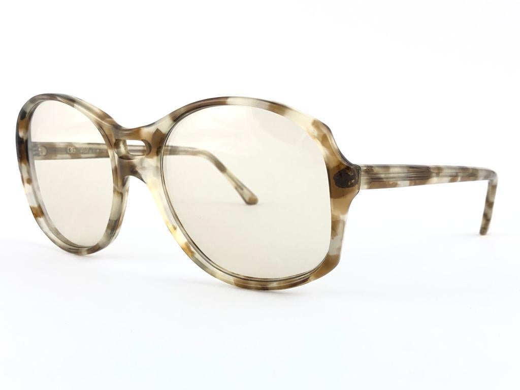 Oversized pair of Oliver Goldsmith sunglasses. 
Light tortoise patern frame holding a pair of light lenses. 

This pair have minor sign of wear due to storage.

Handmade in England.


MEASUREMENTS

FRONT 15 CMS

LENS HEIGHT : 5.3 CMS

LENS WIDTH :