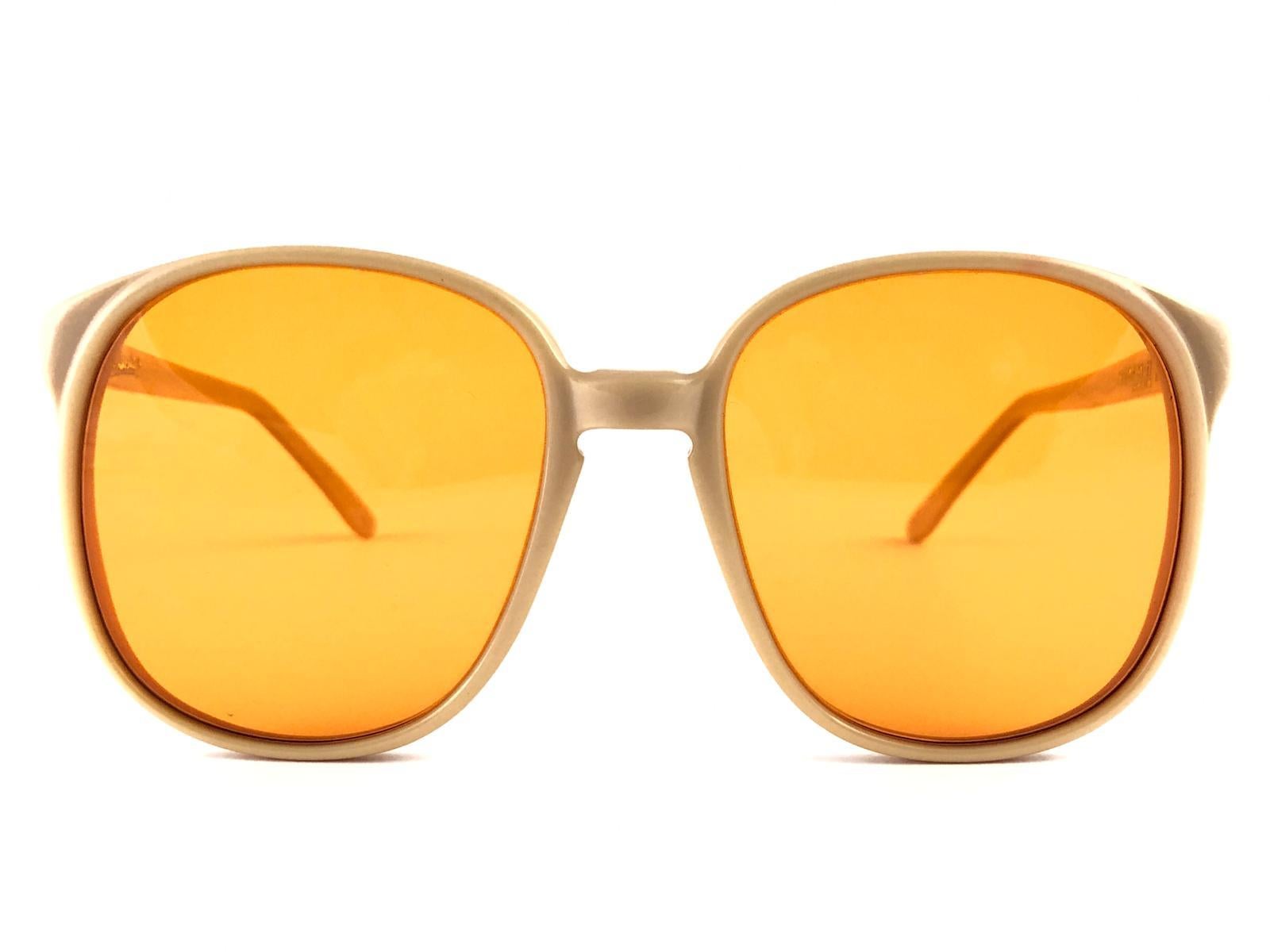 Oversized pair of Oliver Goldsmith sunglasses.  

New, unworn frame holding a pair of tangerine lenses.   

 This pair have minor sign of wear due to storage.

Handmade in England.


MEASUREMENTS

FRONT : 13.5 CMS

LENS HEIGHT : 5.3 CMS

LENS WIDTH