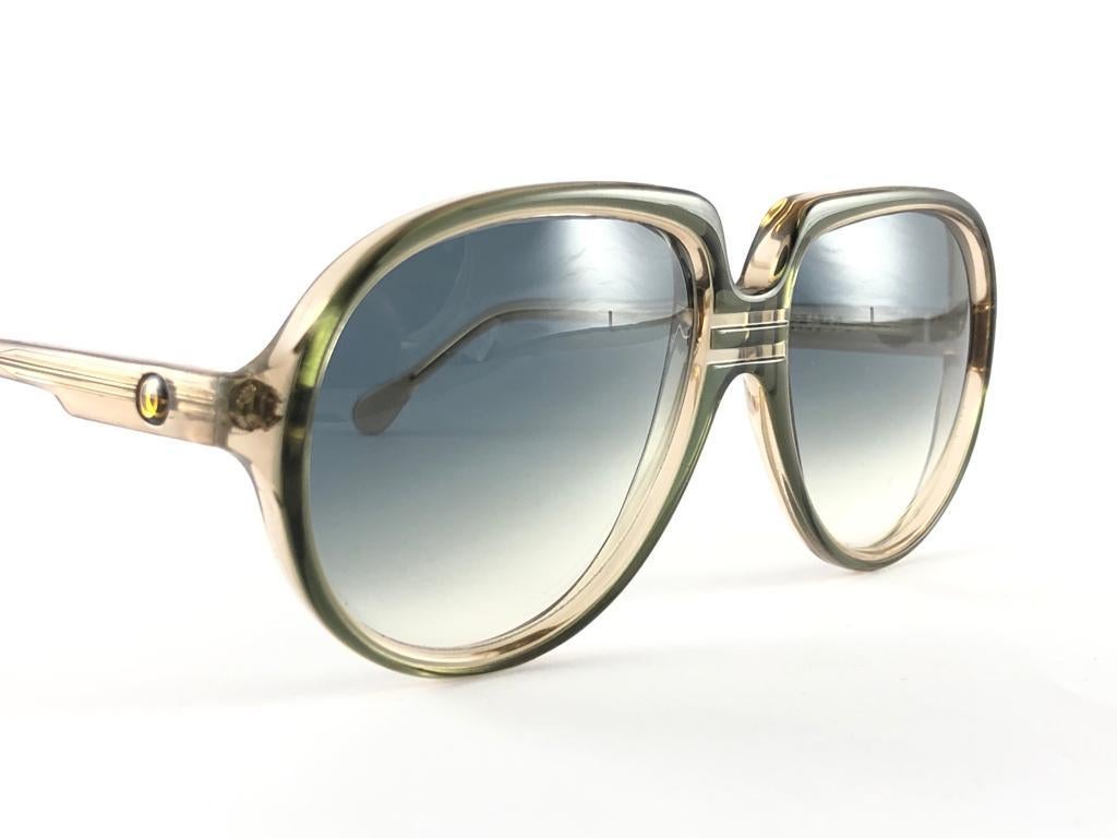 Oversized pair of Oliver Goldsmith sunglasses. 

Translucent olive green frame holding a pair of gradient lenses. 

This pair may show some minor sign of wear due to storage and past of time

Handmade in England.

Frame Width             14.5