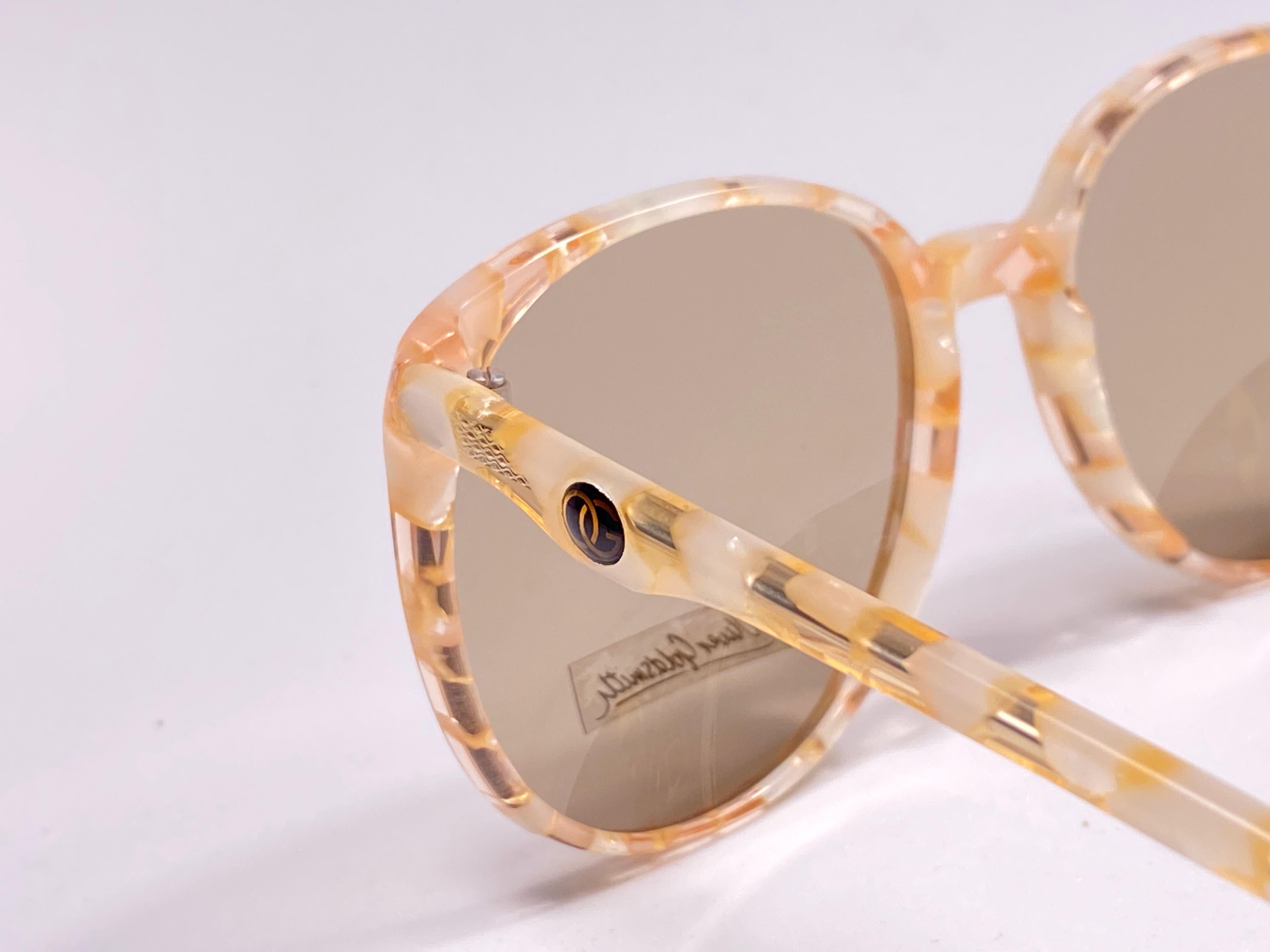 Rare pair of Oliver Goldsmith sunglasses. 
Oversized translucent beige and brown undertones frame holding a pair of medium blue lenses.   

 This pair have minor sign of wear due to storage.

Handmade in England.

MEASUREMENTS :



FRONT :