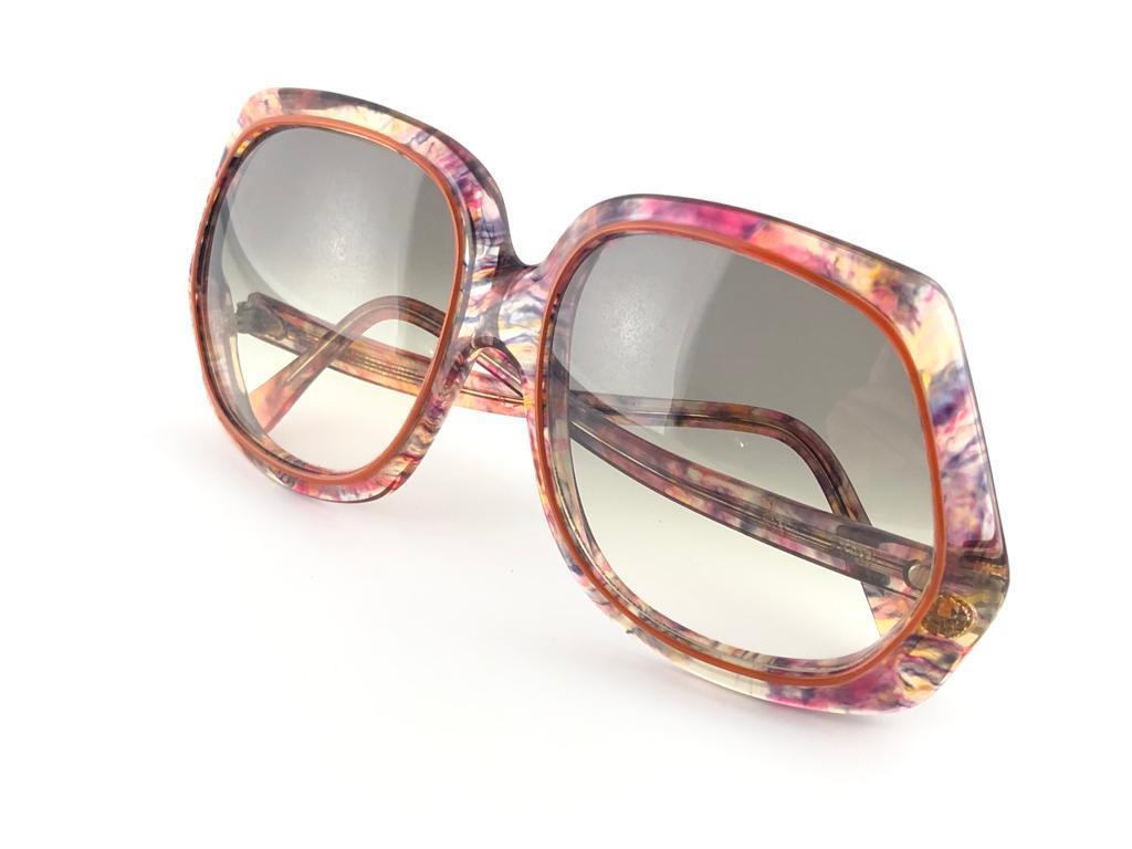 Oversized pair of Oliver Goldsmith sunglasses. 
Multicolor patern frame holding a pair of light lenses. 

This pair have minor sign of wear due to storage.

Handmade in England.


MEASUREMENTS

FRONT 14.5 CMS

LENS HEIGHT : 5.4 CMS

LENS WIDTH : 5.3