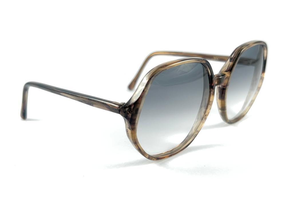 Oversized Pair Of Oliver Goldsmith Sunglasses 
Tortoise Patern Frame Holding A Pair Of Medium Blue Lenses
This Item May Show Some Minor Sign Of Wear Due To Storage And Past Of Time


Handmade In England.



Frame Width                           14