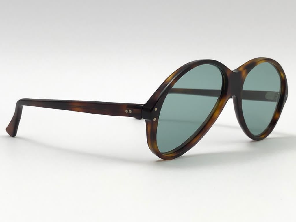 Black pair of Oliver Goldsmith sunglasses.  

Oversized dark tortoise frame holding a pair of blue flat lenses.   

 This pair have minor sign of wear due to storage.

Handmade in England.

