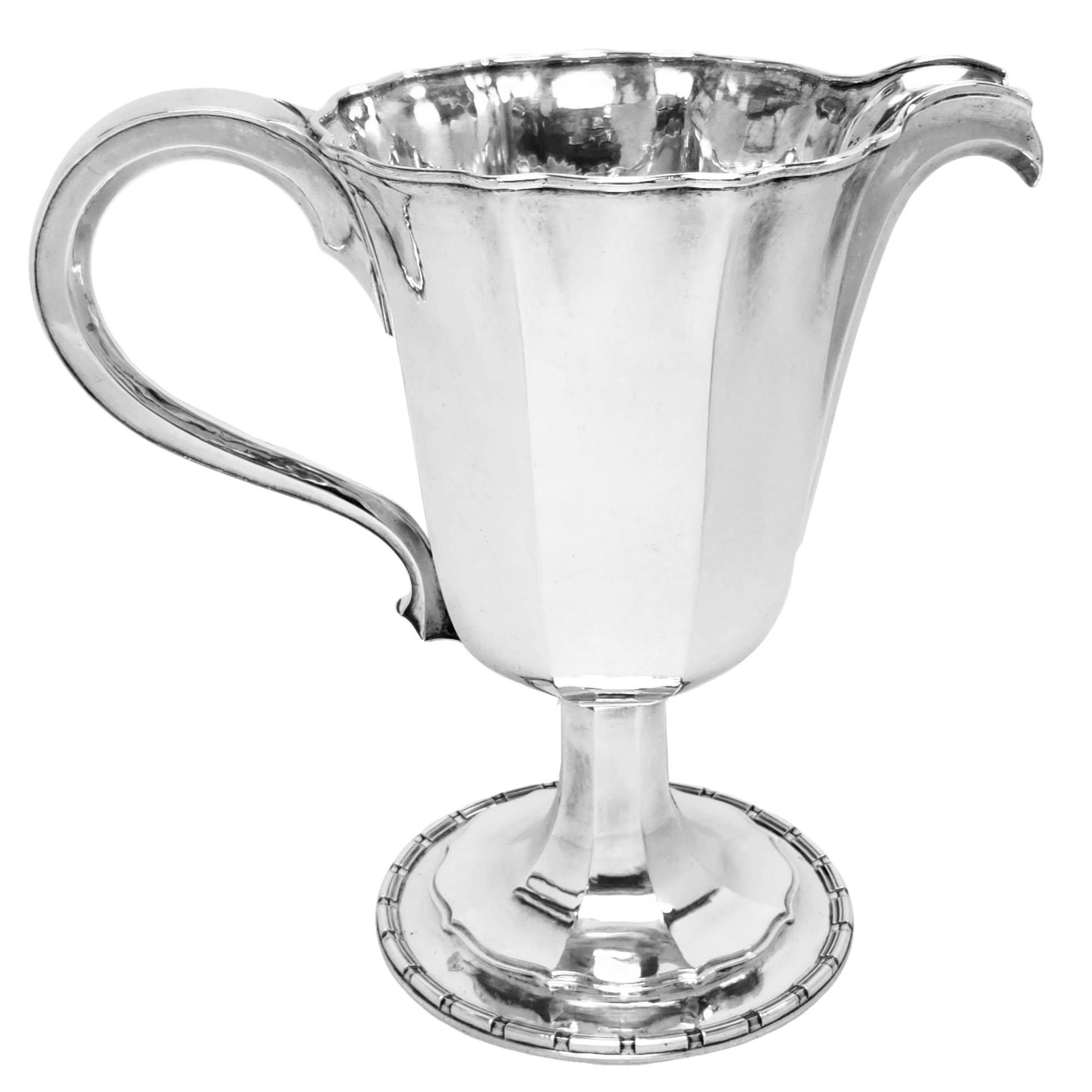 A substantial Sterling Silver Jug by Omar Ramsden. This Silver Arts & Crafts style Silver Pitcher has an Octagonal Body on an unusual shaped spread foot. The Silver Serving Jug is of a large size and suitable as a water or cocktail pitcher.

Made in
