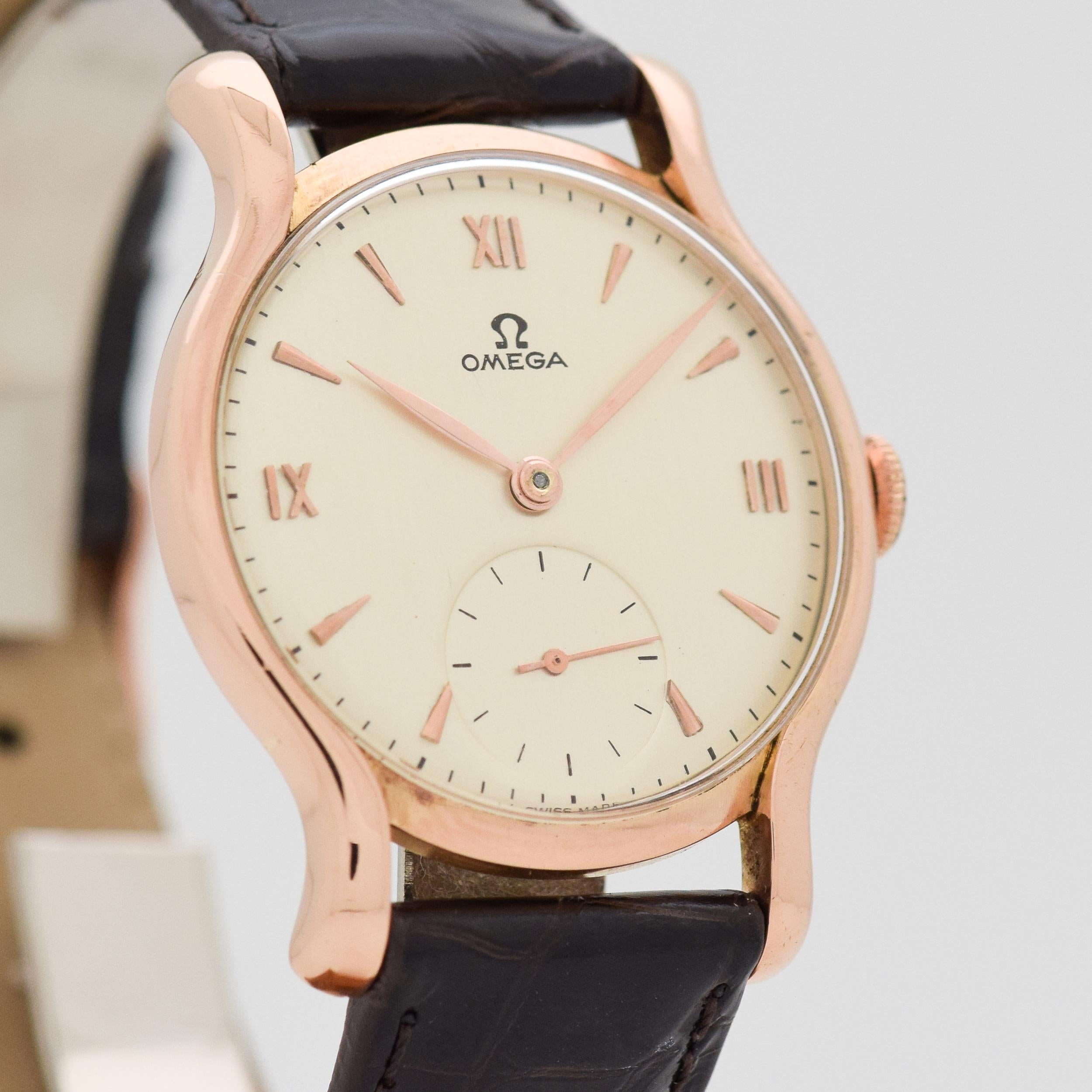 1944 Vintage Omega 18k Rose Gold watch with Silver Dial with Applied Rose Roman Numerals III, IX, and XII with Elongated Triangle Markers. 33mm x 41mm lug to lug (1.3 in. x 1.61 in.) - 17 jewel, manual caliber movement. Equipped with a 100% Genuine