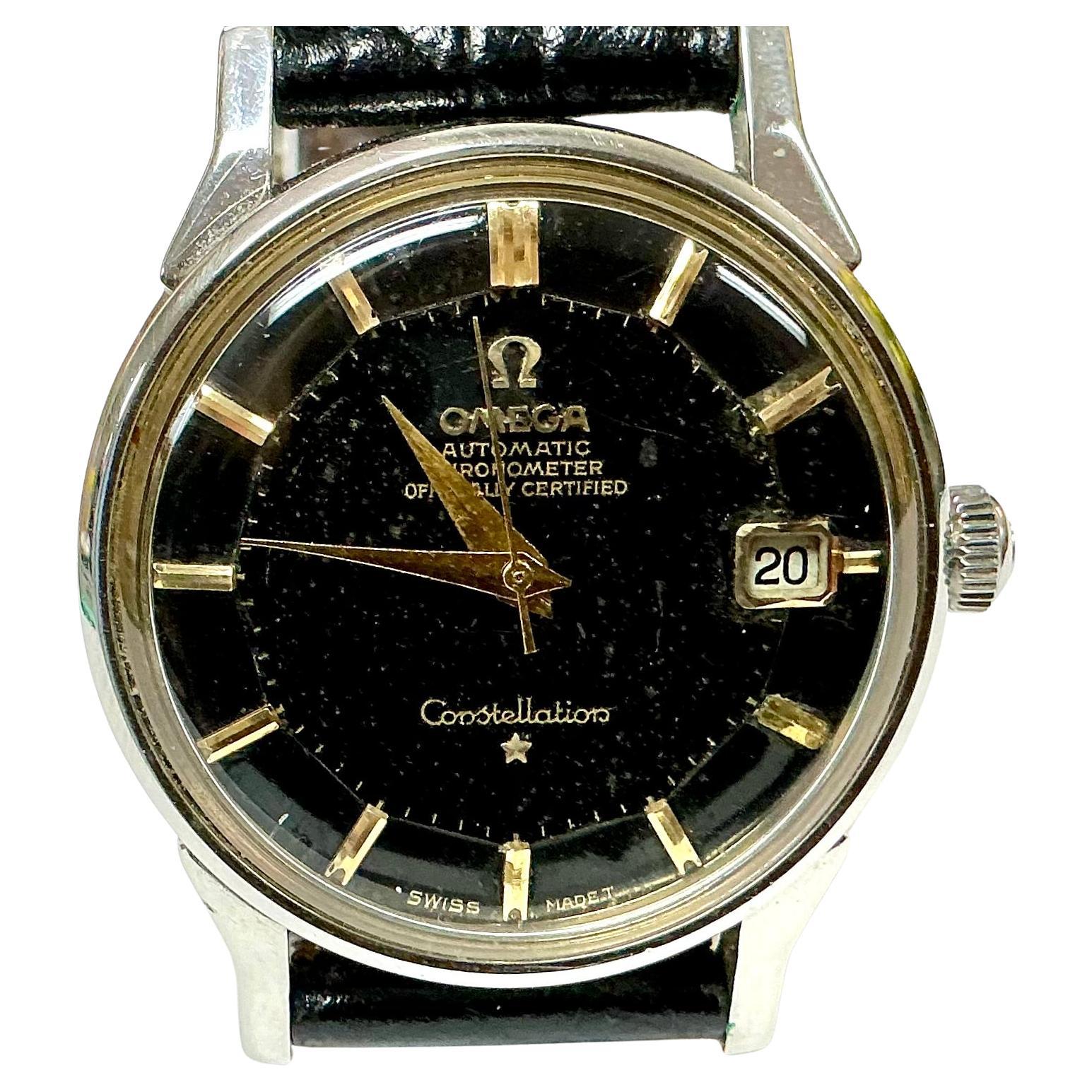 Vintage Omega Black Dial Constellation Automatic Wrist Watch. Pre-owned Constellation Omega Watch has a 33mm stainless steel case and beveled black dial. Watch has a luxurious 8 inch alligator grain black leather band. DeBeer EUROPA is embossed on
