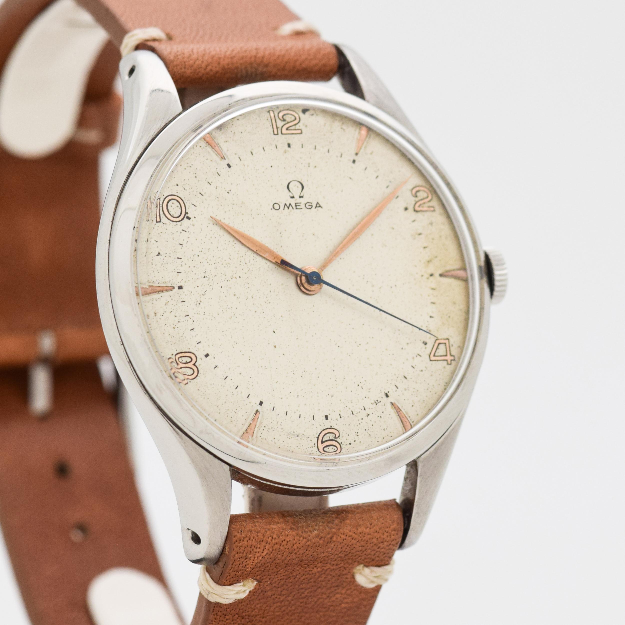 1949 Vintage Omega Jumbo 38 mm Wide Ref. 2506-5 Stainless Steel watch with Original Two Tone Silver Dial with Painted Even Arabic Numbers with Applied Elongated Rose Color Triangles. Powered by a 17-jewel, manual caliber movement. Triple Signed.