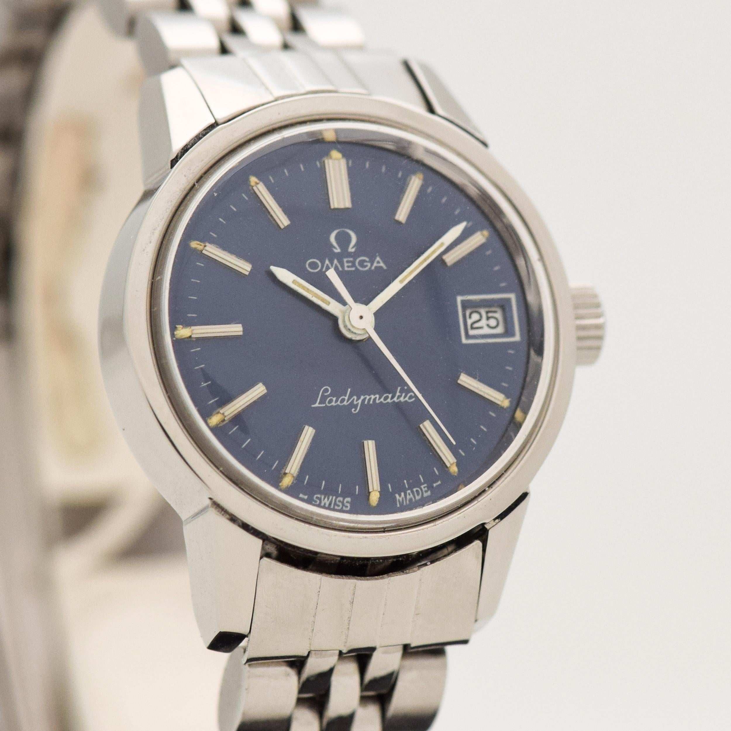 1973 Vintage Omega Ladies Ladymatic Ref. 5660045 Stainless Steel watch with Original Blue Dial with Applied Steel Beveled Stick/Bar/Baton Markers with White Inlay with Original Omega Stainless Steel Bracelet. Case size, 22mm x 27mm lug to lug. 