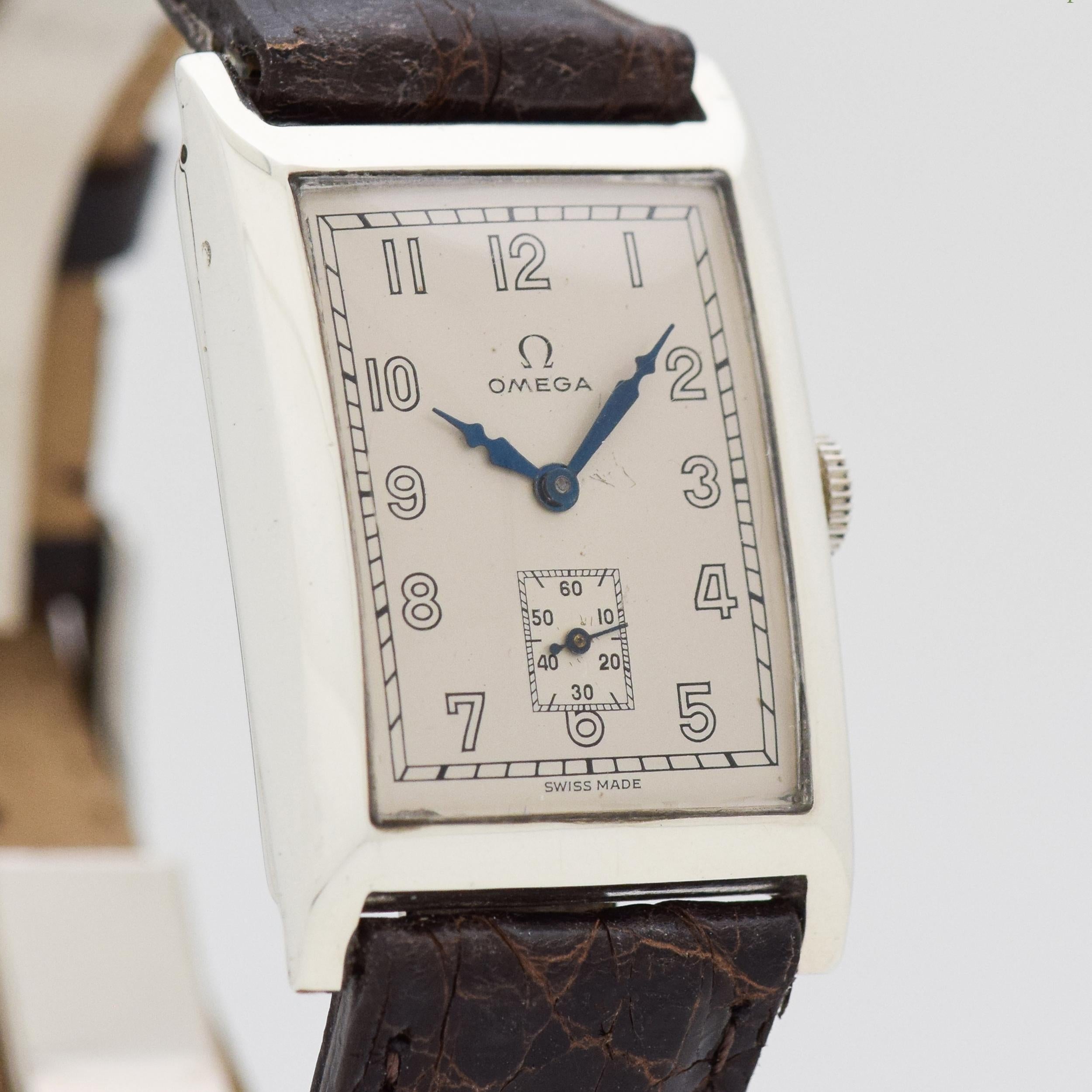 1929 Vintage Omega Rectangular-shaped Silver Watch. Original, restored dial with open-Arabic numerals & Blued Steel hands. 24mm x 38mm. Equipped with a 15-jewel, manual caliber movement. Featured on a 100% Genuine Crocodile Glossy Dark Chocolate