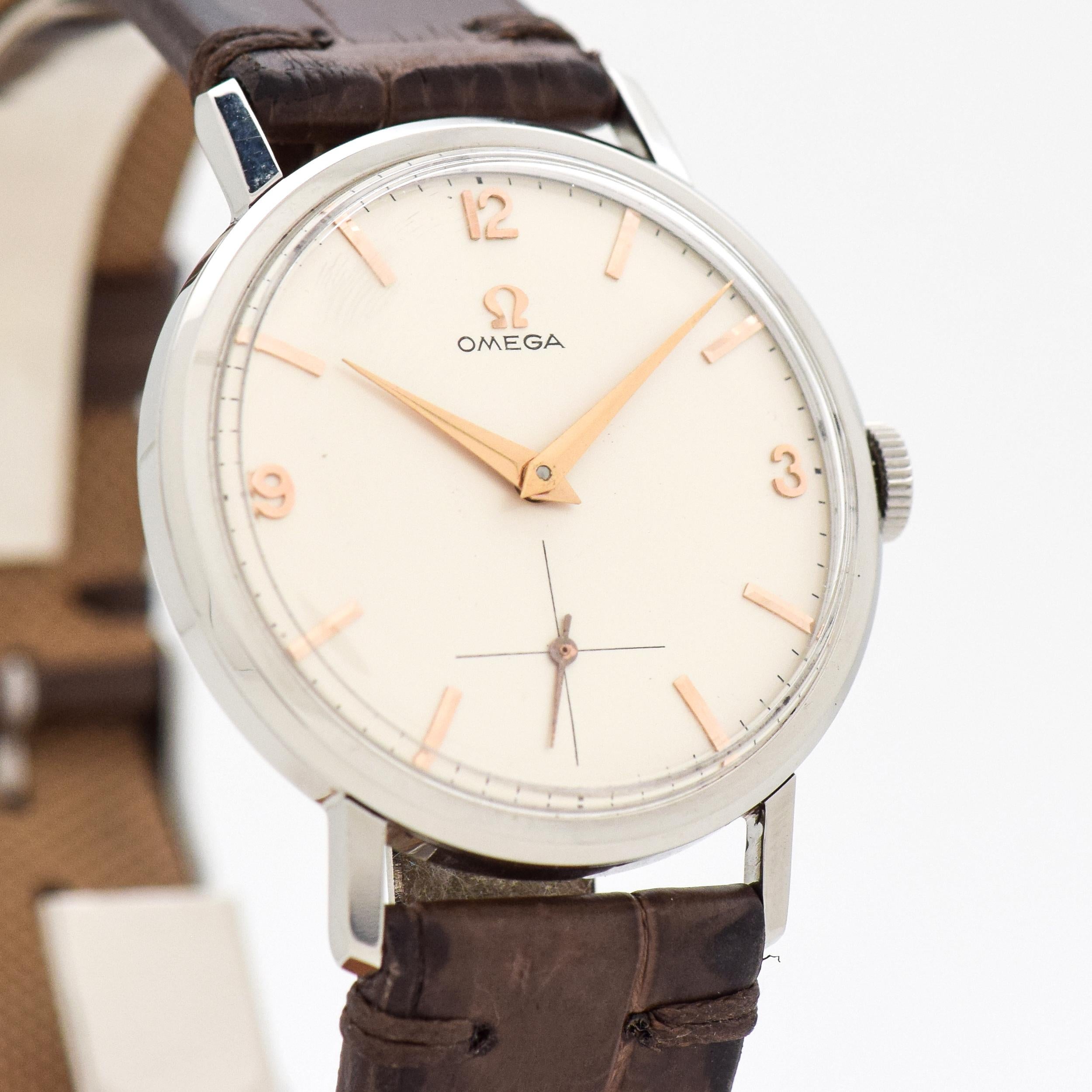 1961 Vintage Omega Reference 131.002-64-SC Stainless Steel Watch. Original, silver dial with applied, Arabic numerals & bar markers. 34mm x 40mm. 17 jewel, manual caliber 268 movement. 100% Genuine Alligator Matte Dark Chocolate-colored Watch Strap.