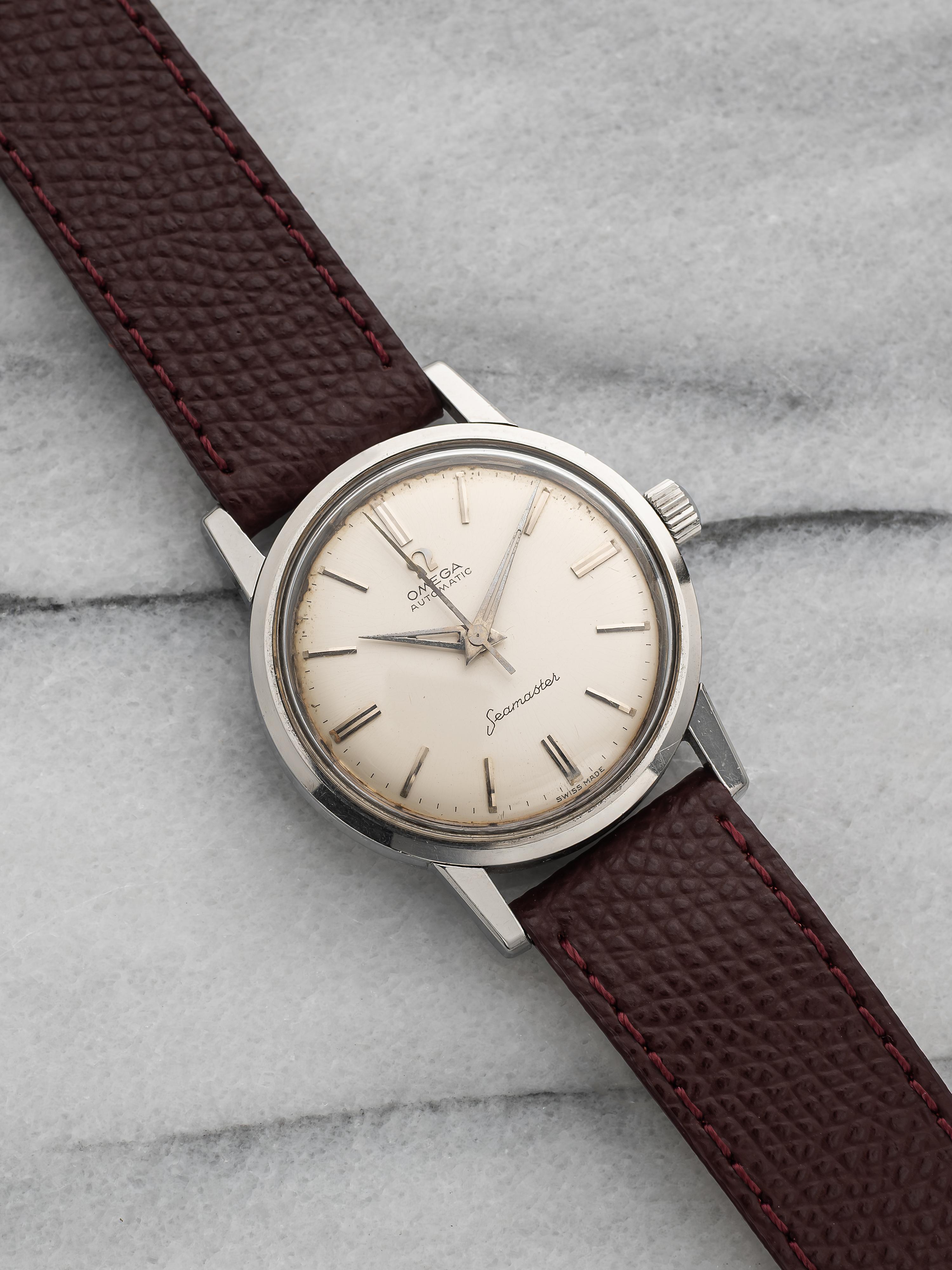 Aquí tienes un Omega Seamster vintage con esfera blanca/crema de los años 60. Mantiene la hora y es totalmente funcional. Las medidas incluyen un tamaño de la caja de 34 mm y una anchura de las asas de 18 mm.  Lleva una correa de cuero granate con