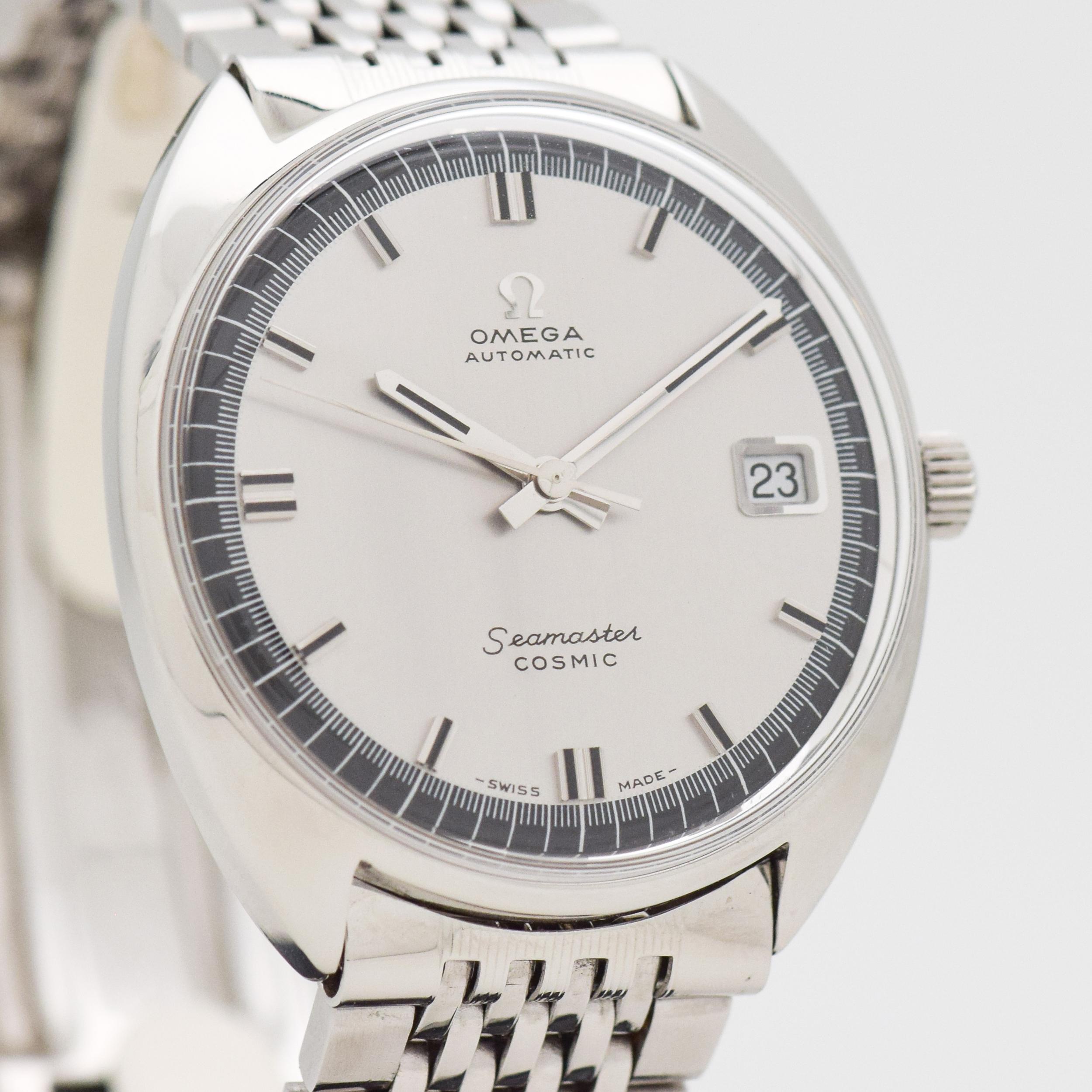 a 1968 Vintage Omega Seamaster Cosmic. Reference 166.026. Stainless Steel, C-shaped watch case. 35mm wide. Original, two-tone: gray & black-colored dial. Equipped with a date function. Powered by a 24-jewel, automatic caliber movement. Featured on