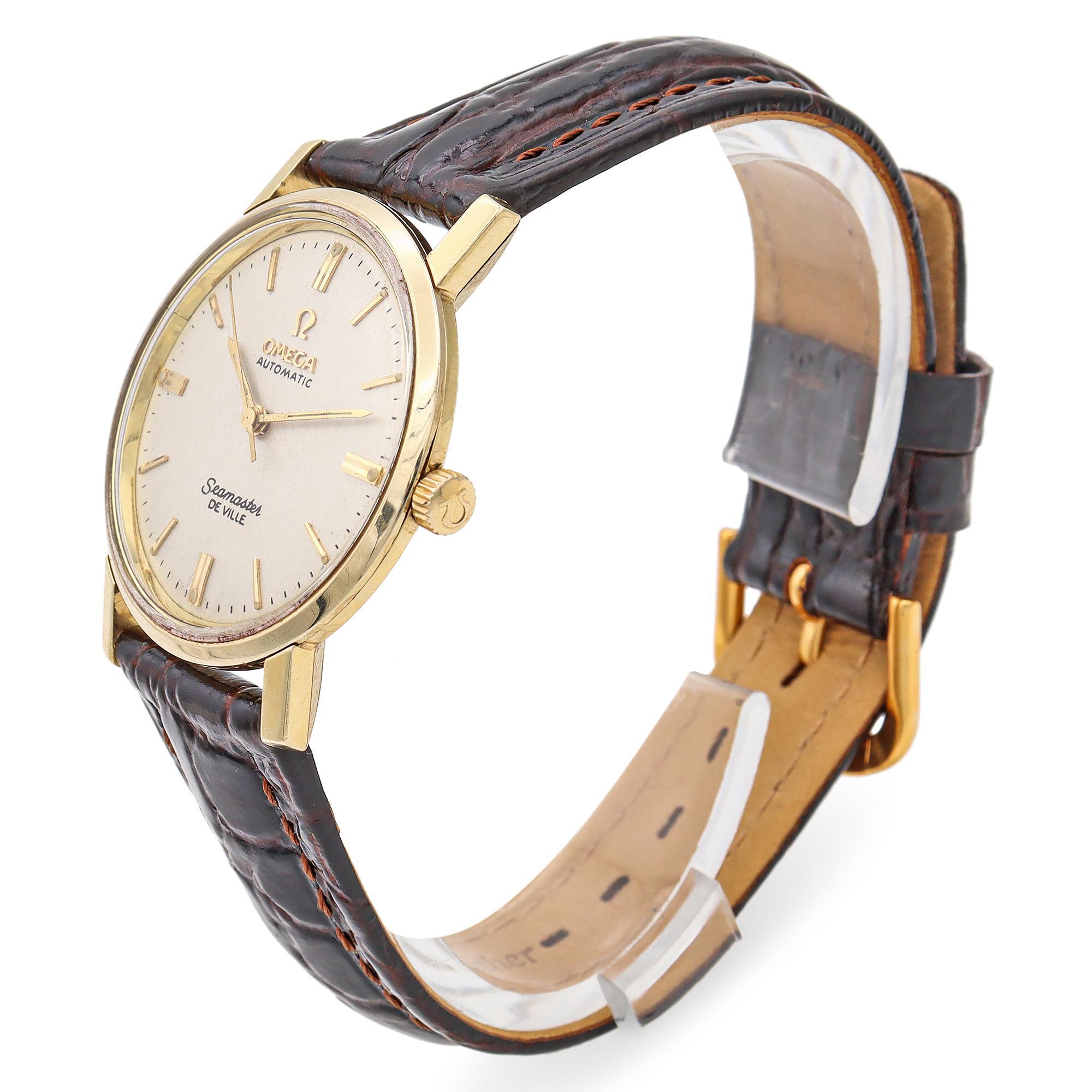 A classic Omega Seamaster De Ville watch. This exquisite timepiece is crafted in 14k gold, showcasing a timeless elegance. The round case features a smooth, polished finish, complementing the understated dial. The dial is adorned with gold hour