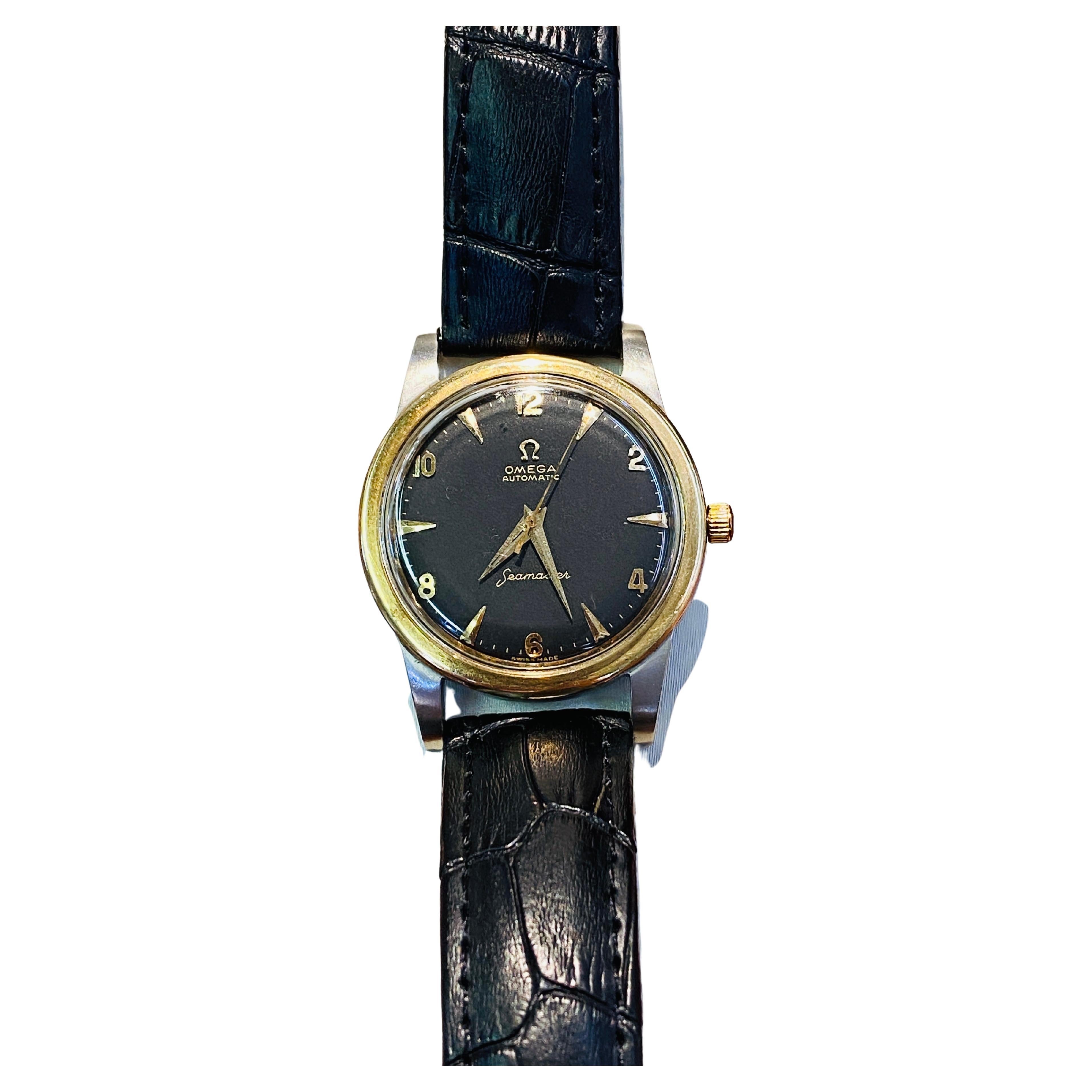 Vintage Omega Seamaster automatic men’s watch with 18k yellow gold crown, bezel and hands, black dial and black leather band. Case is stainless steel. Circa 1958.