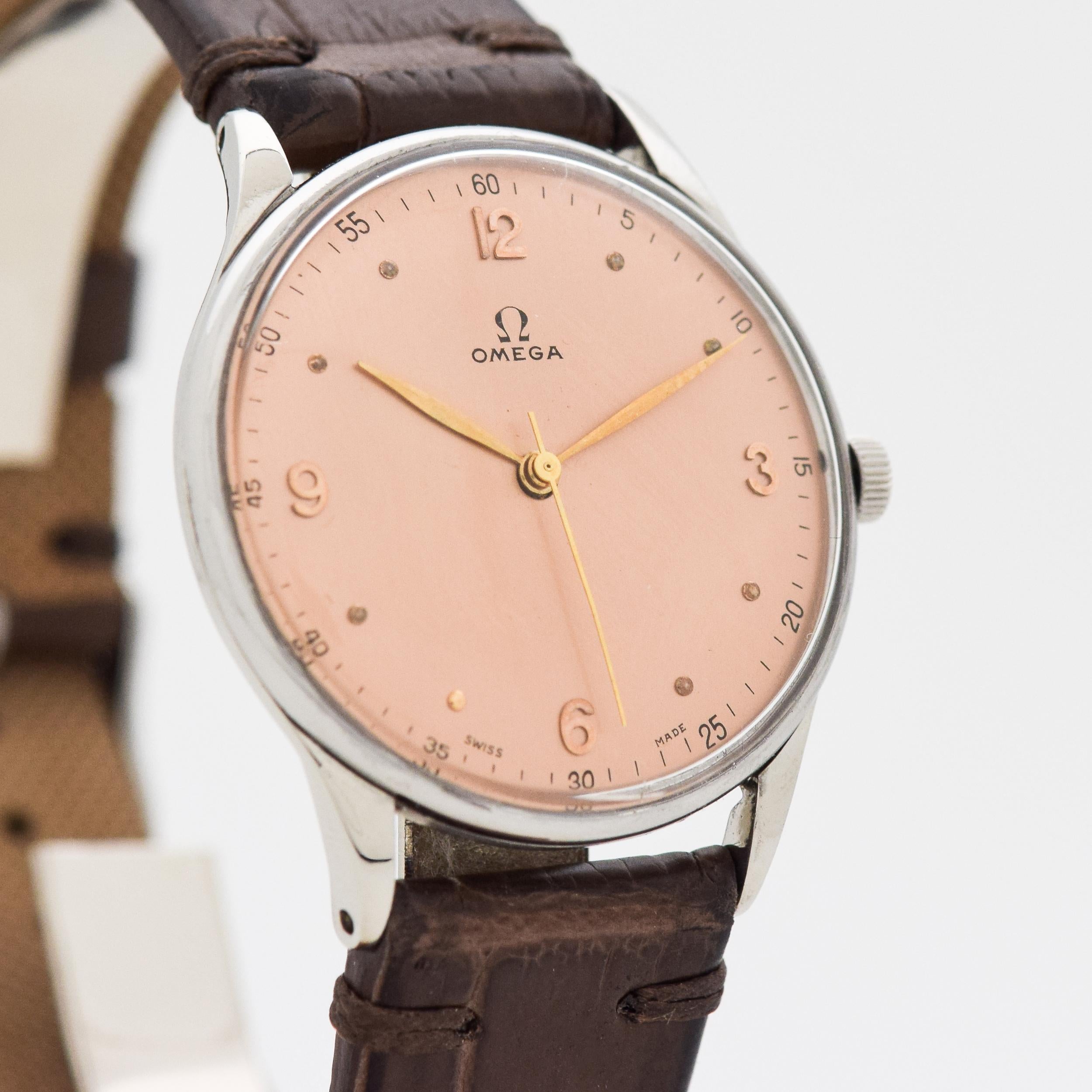 1947 Vintage Omega Stainless Steel watch with Original Salmon Dial with Attached Gold Color Arabic 3, 6, 9, and 12 with Dot Markers with Original Omega Box. 34mm x 40mm lug to lug (1.34 in. x 1.57 in.) - 17 jewel, manual caliber movement. Equipped
