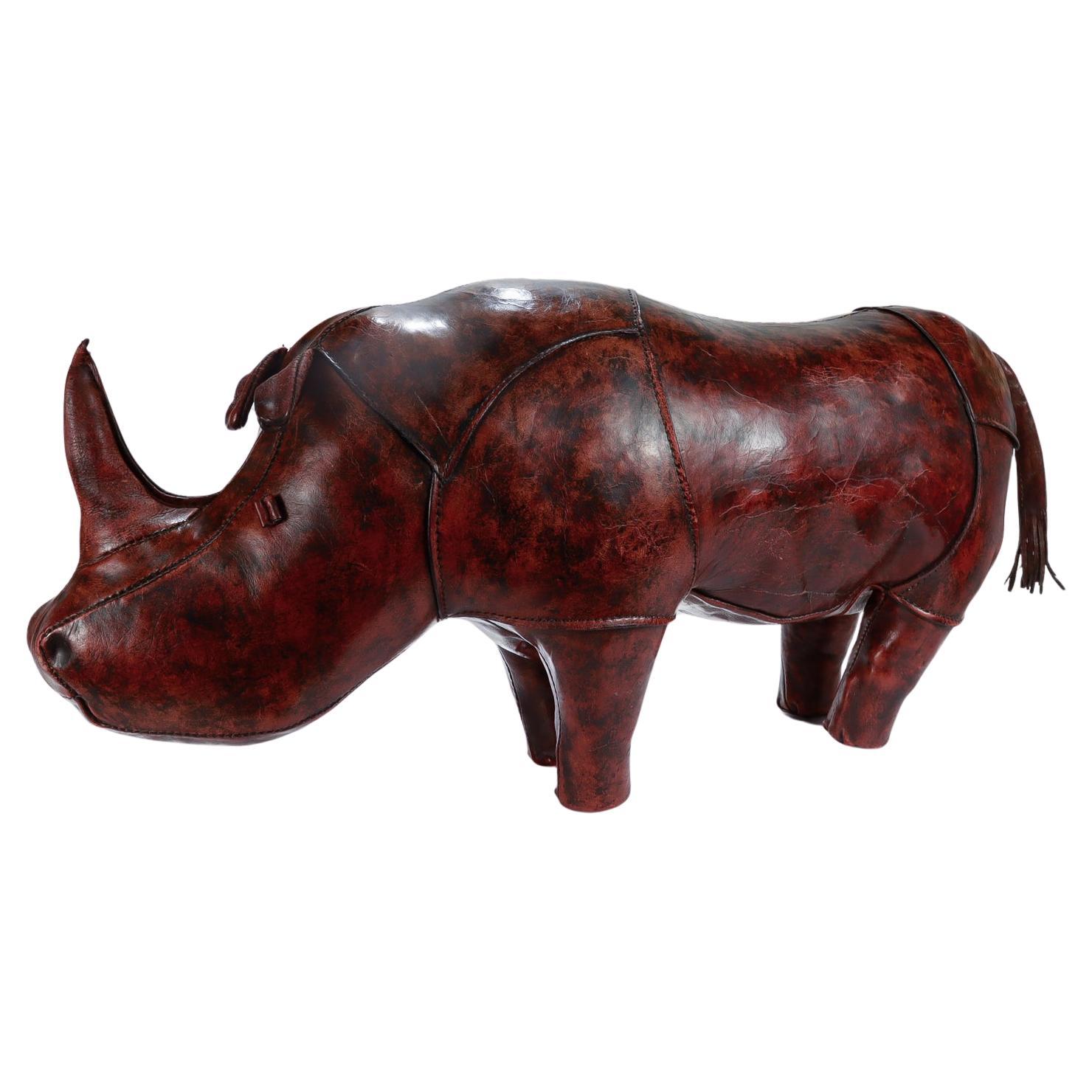 A fine vintage leather footstool.

Designed by Daniel Omersa for Abercrombie & Fitch in the 1960's.

In the form of a standing rhinoceros with its signature folded eyes, floppy ears, and button feet.

Having a wonderfully aged finish with wear in