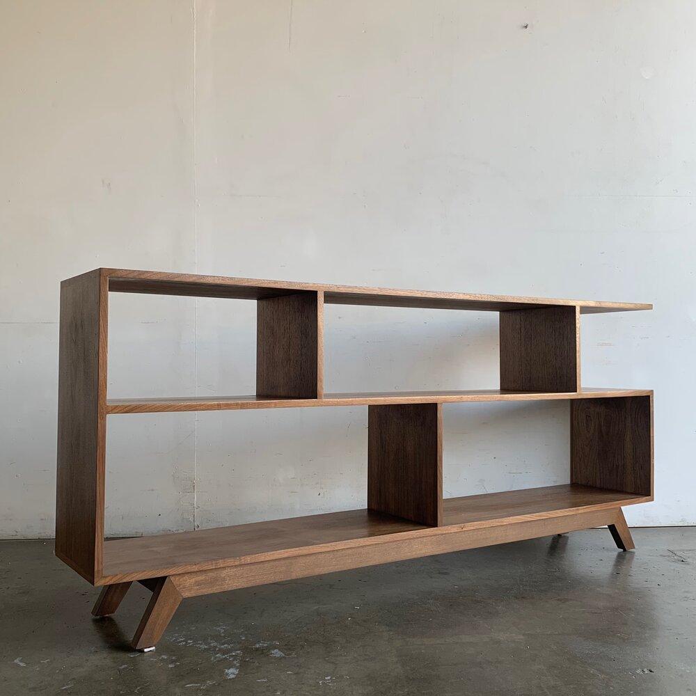 Measures: W72 D13 H32.

Handcrafted walnut bookcase made in a mix of solid and walnut veneer. Item is structurally sound and sturdy, we usually have one floor model in stock. If item is sold out lead time is between 4-6 weeks.